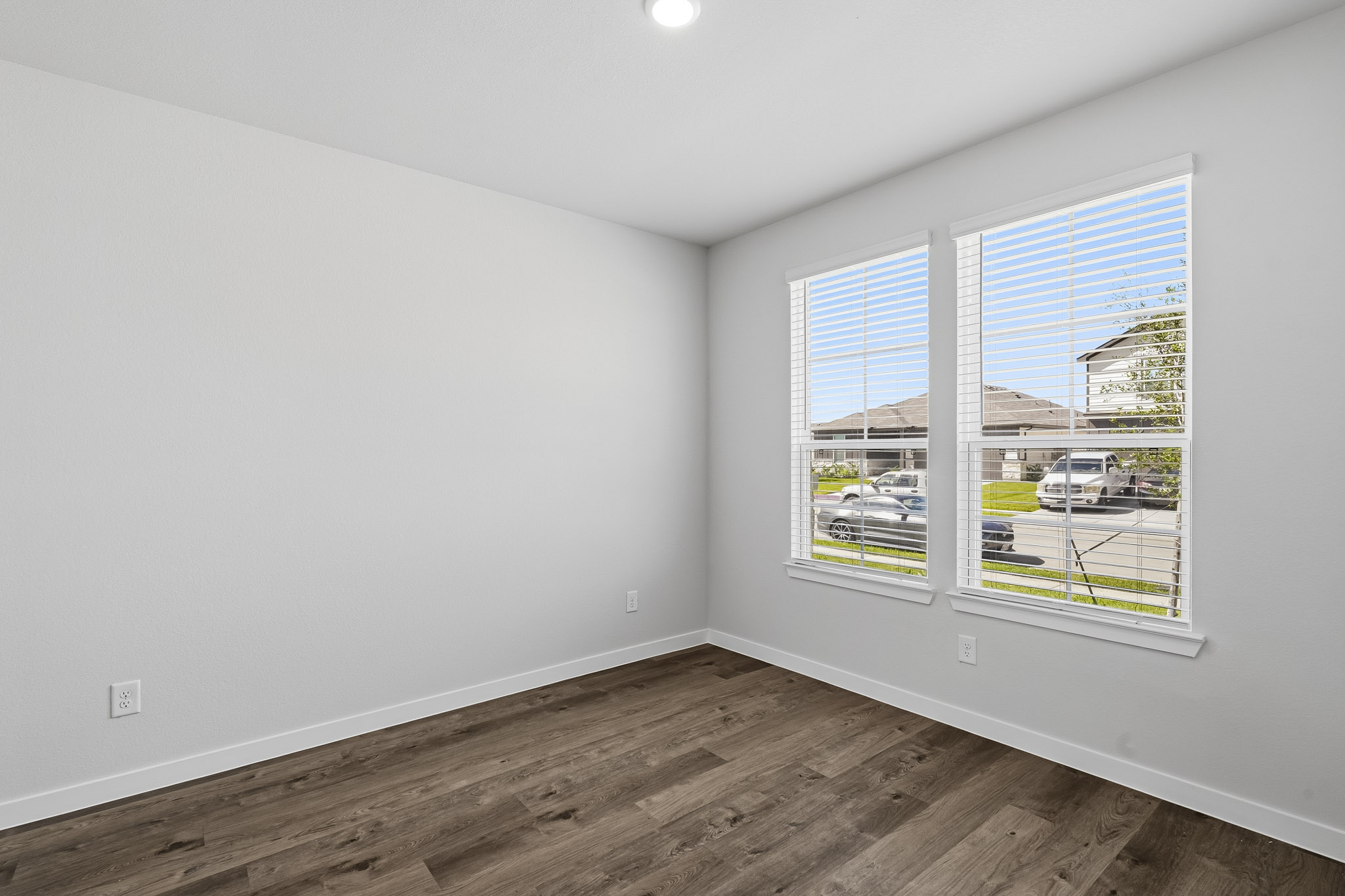 A room with a window and a wood floor.