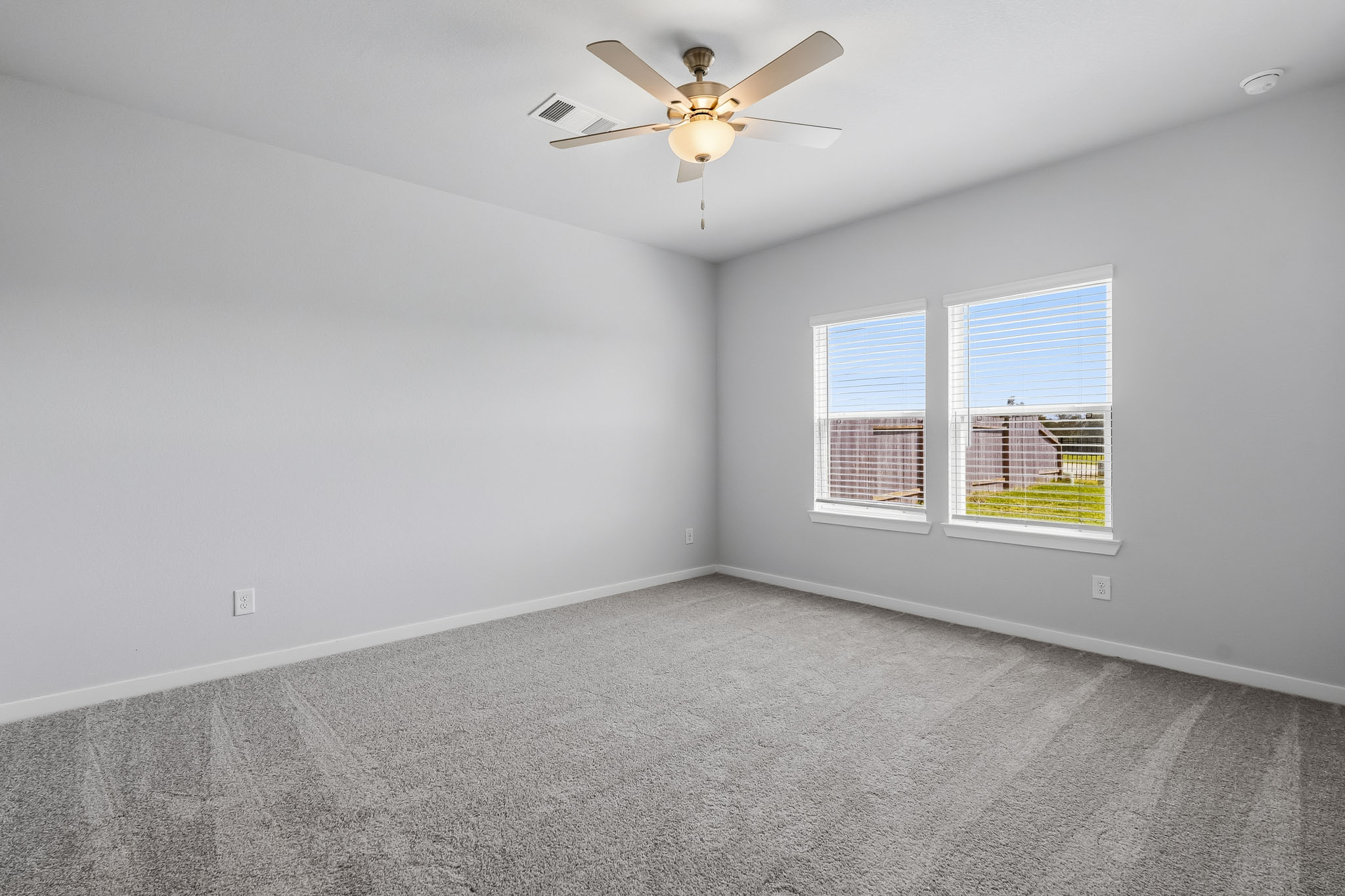 A room with a ceiling fan and a window.