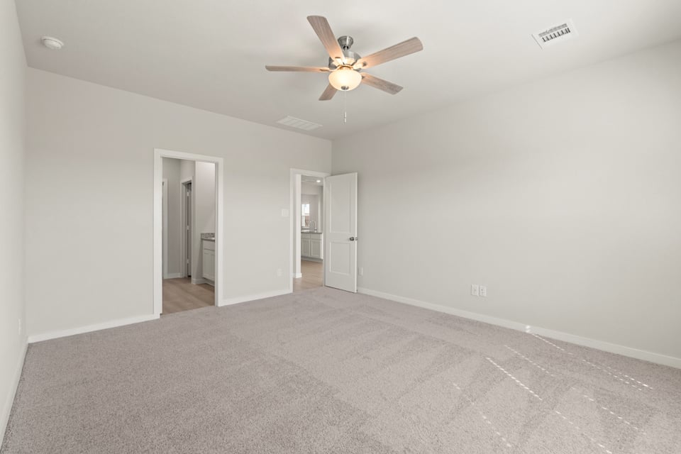 A room with a ceiling fan and a door.