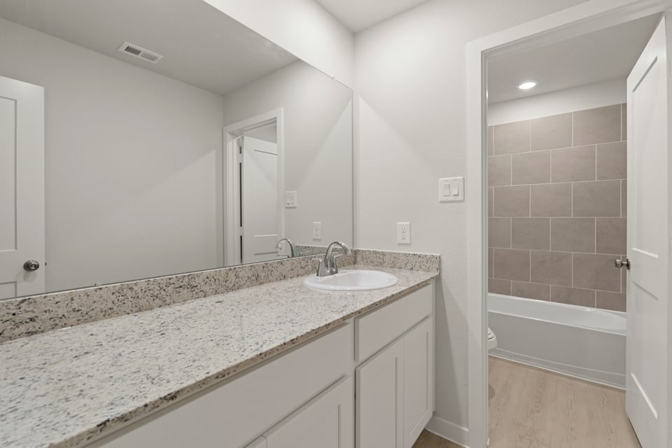 A bathroom with a marble countertop.