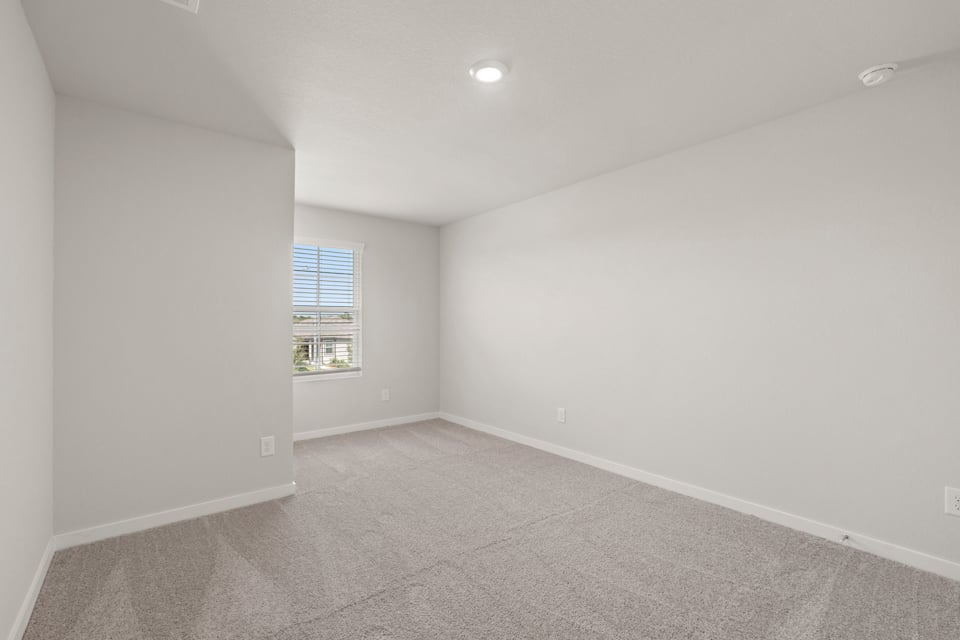 A room with a window and a carpet.