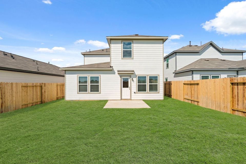 A backyard with a fence and a house.