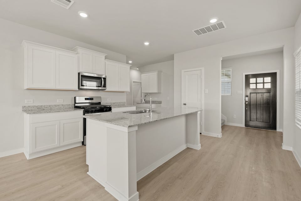 A kitchen with white cabinets.
