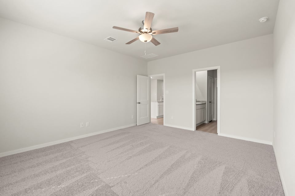 A room with a ceiling fan and a door.