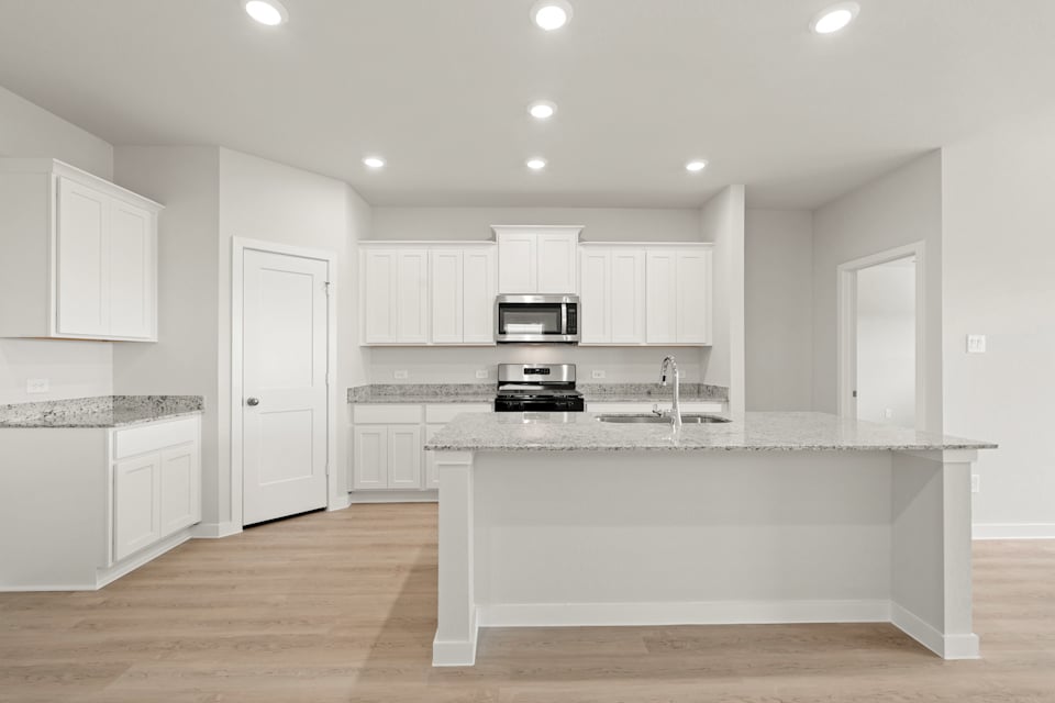 A kitchen with white cabinets.