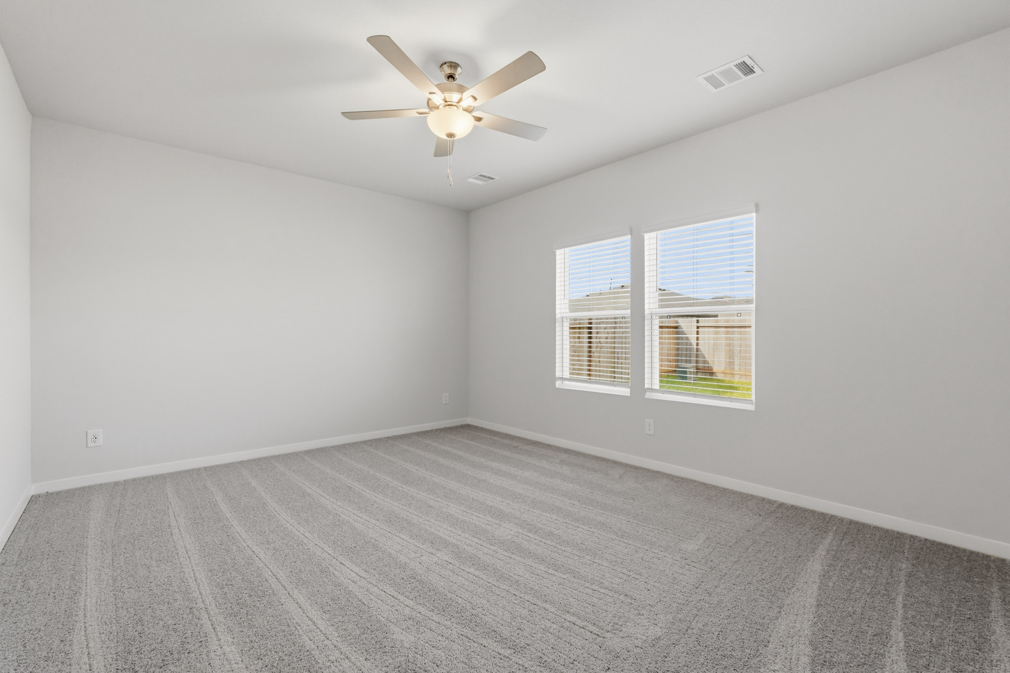 A room with a ceiling fan and a window.