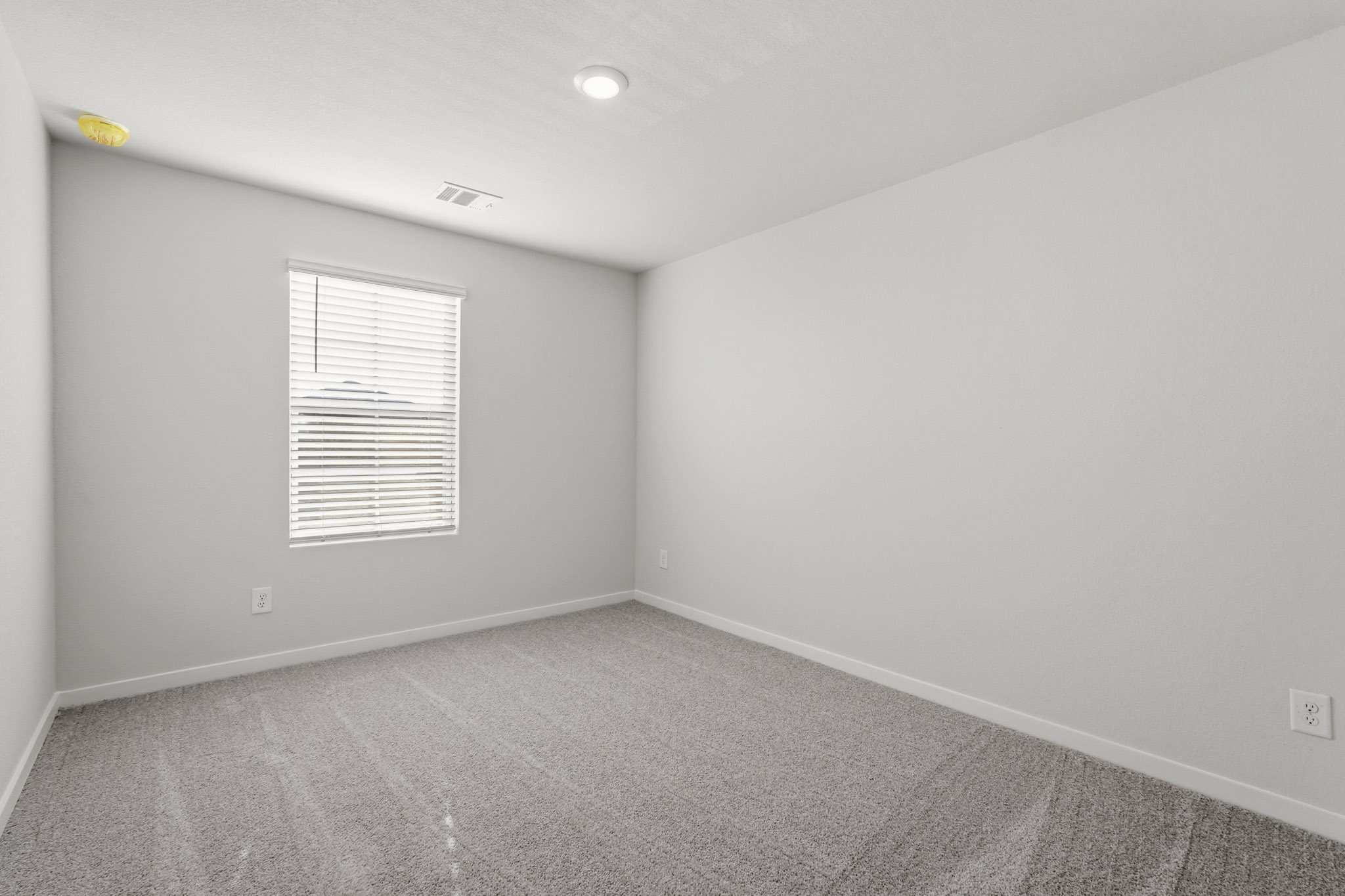 A room with a white wall and a window.