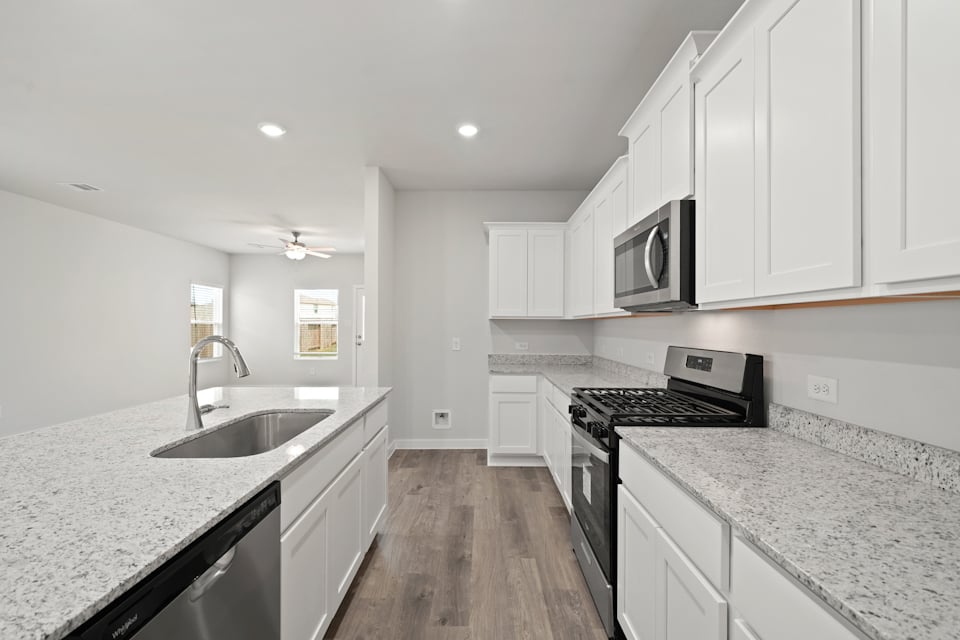 A kitchen with white cabinets.