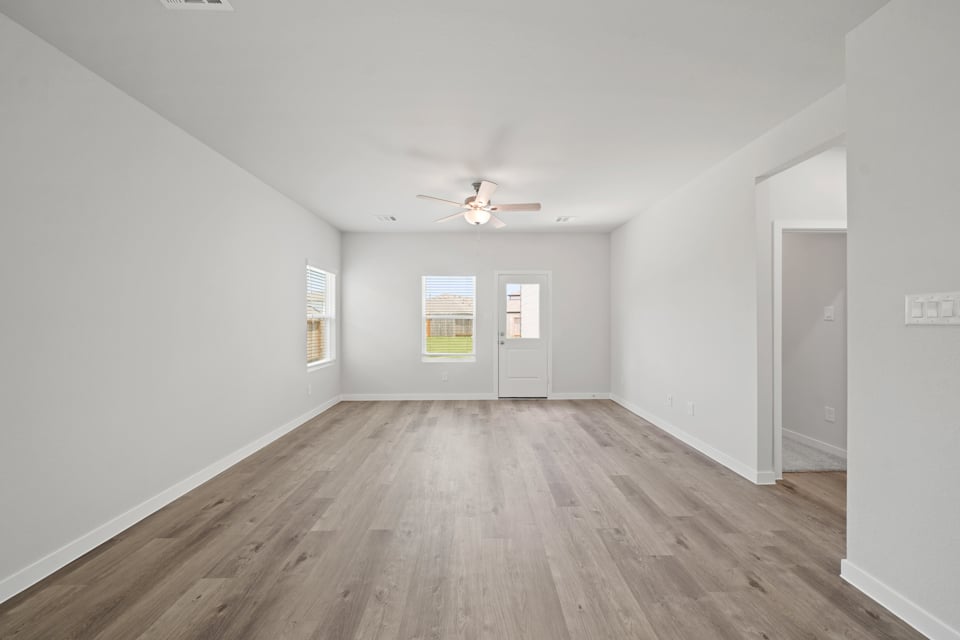 A room with a wood floor and a ceiling fan.