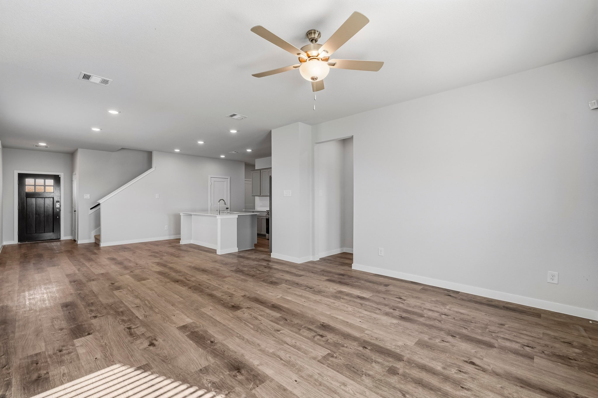 A room with a wood floor and a ceiling fan.