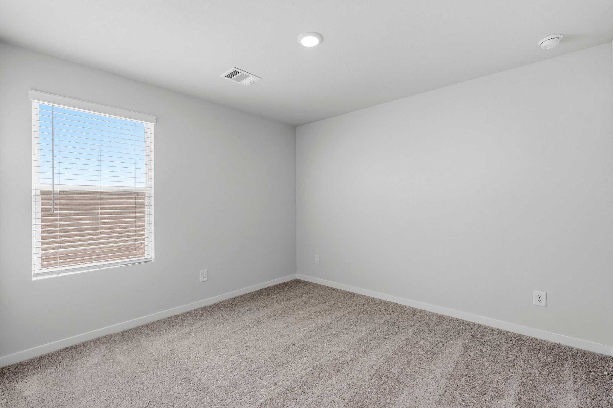 A room with a window and a carpet.