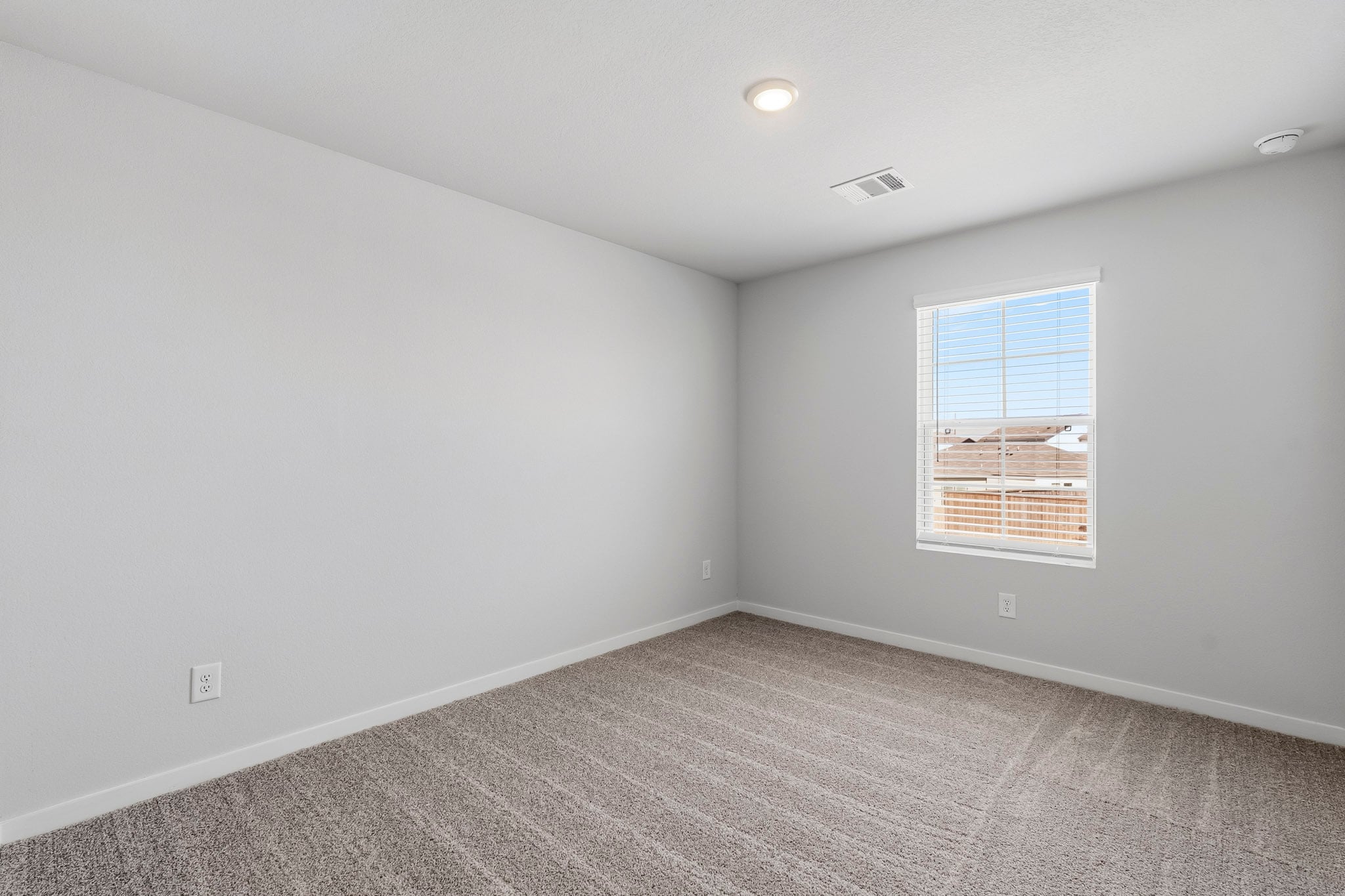 A room with a window and a carpet.