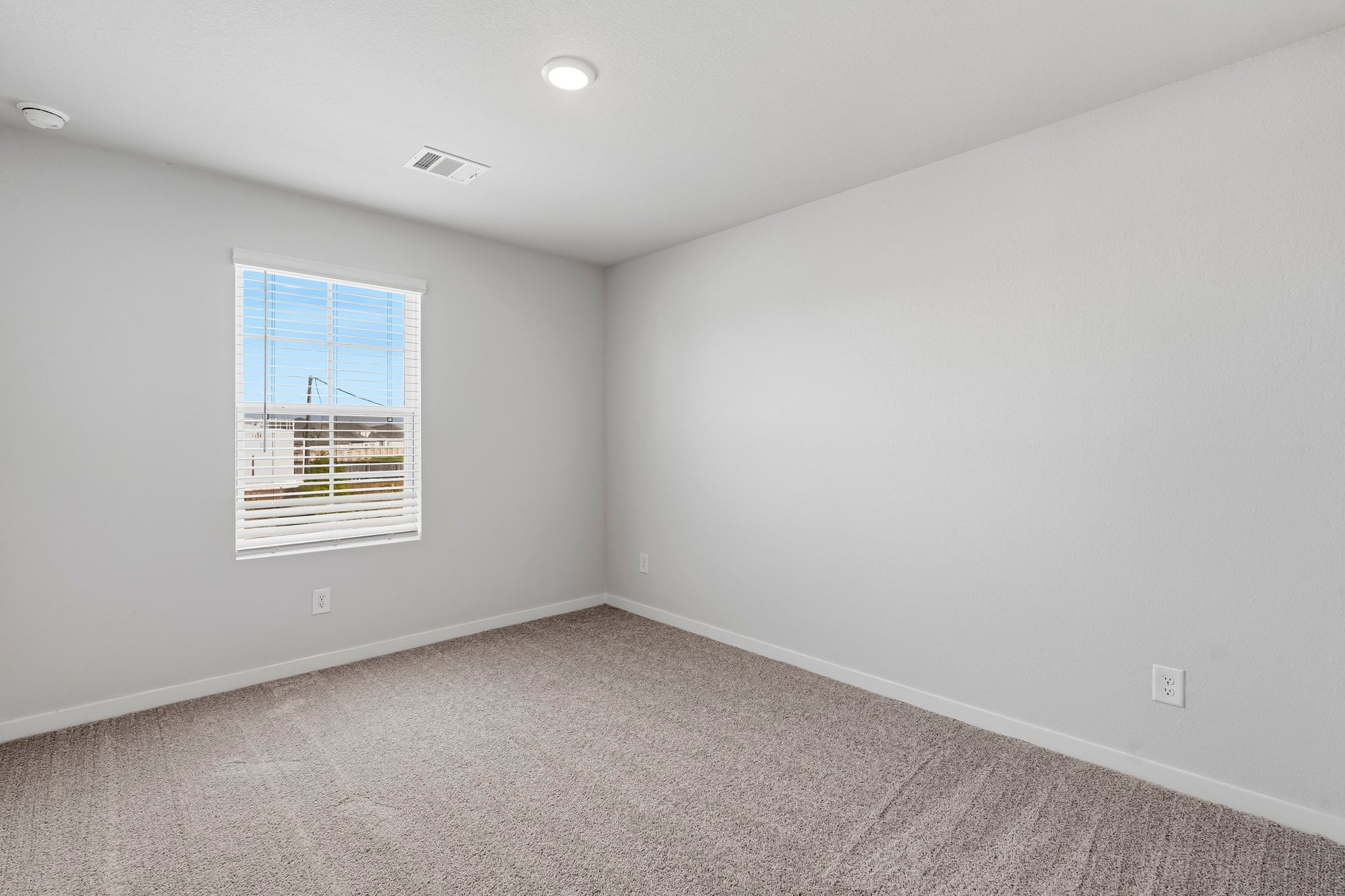 A room with a window and a carpet.