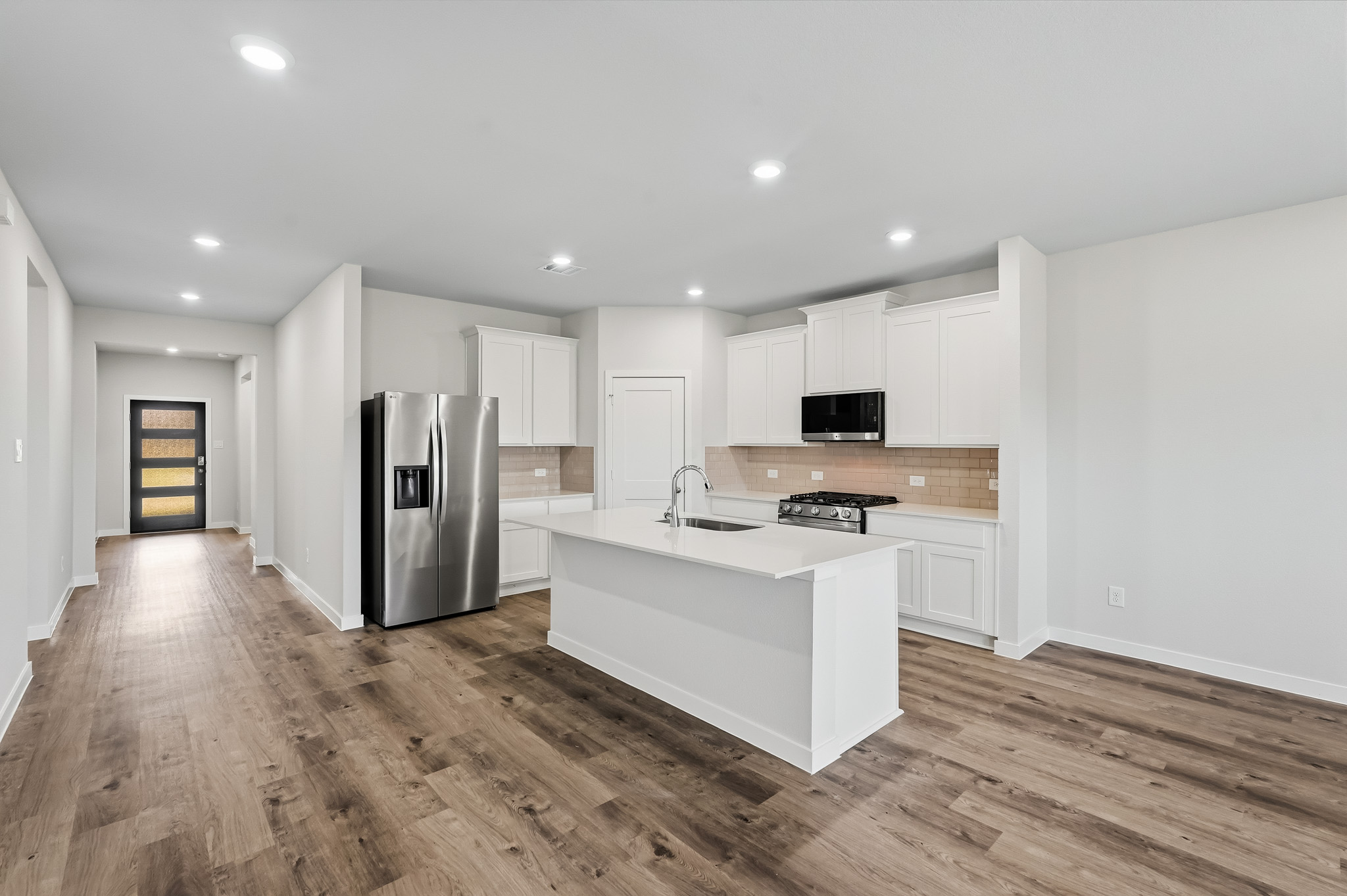 A kitchen with white cabinets.