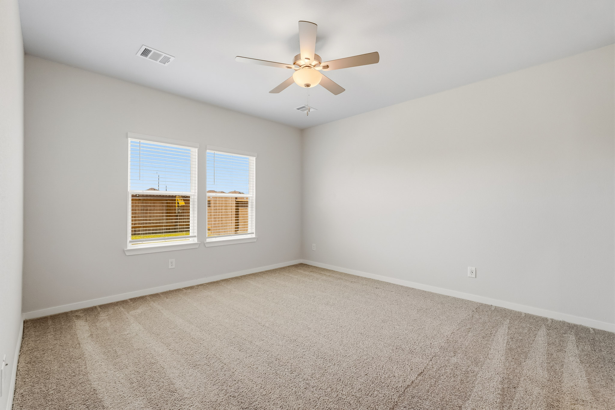 A room with a ceiling fan and a window.