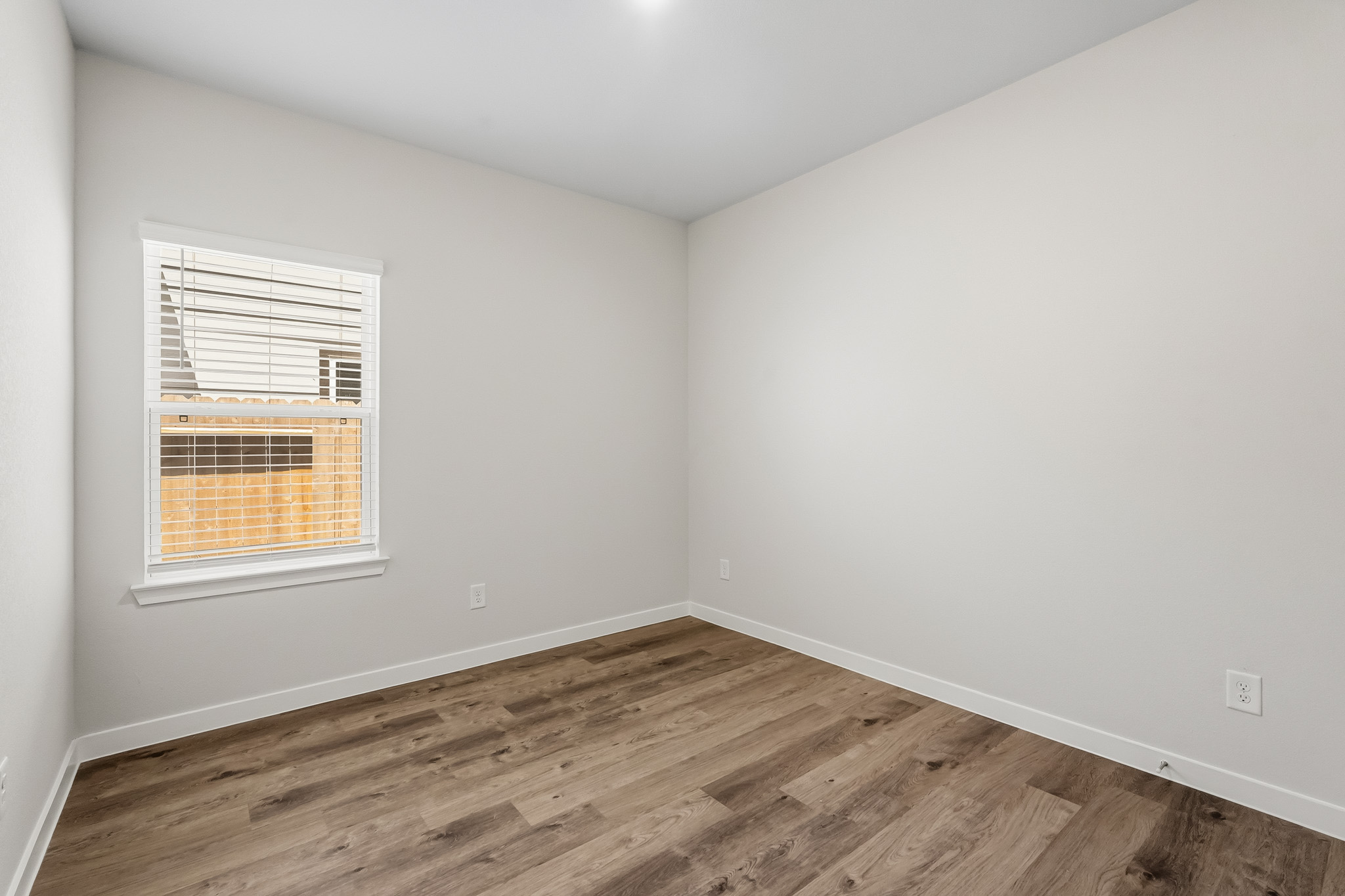 A room with a wood floor and a window.