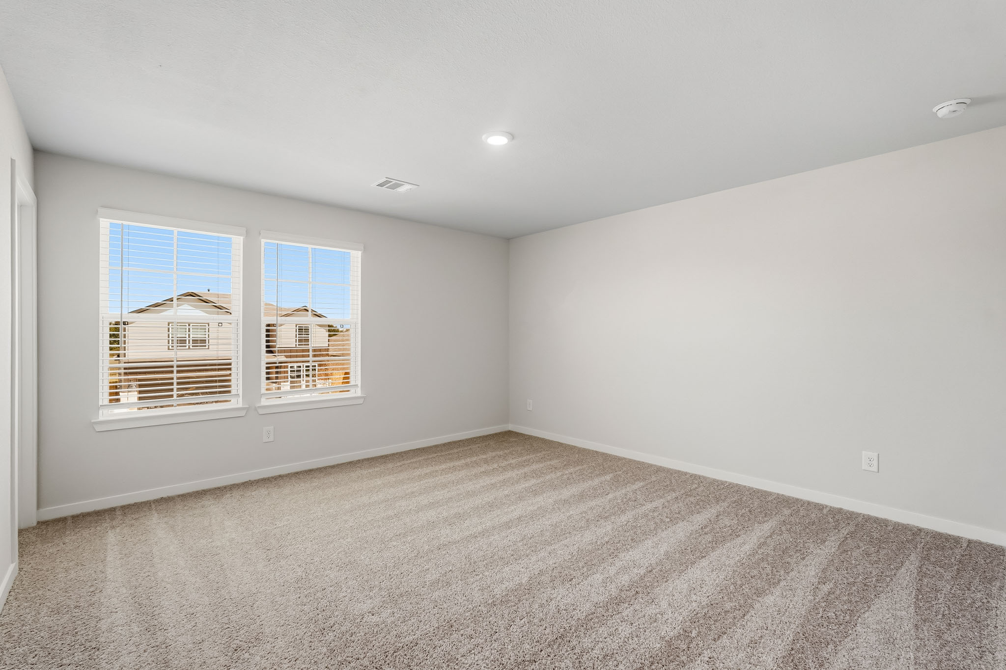 A room with a carpet and windows.