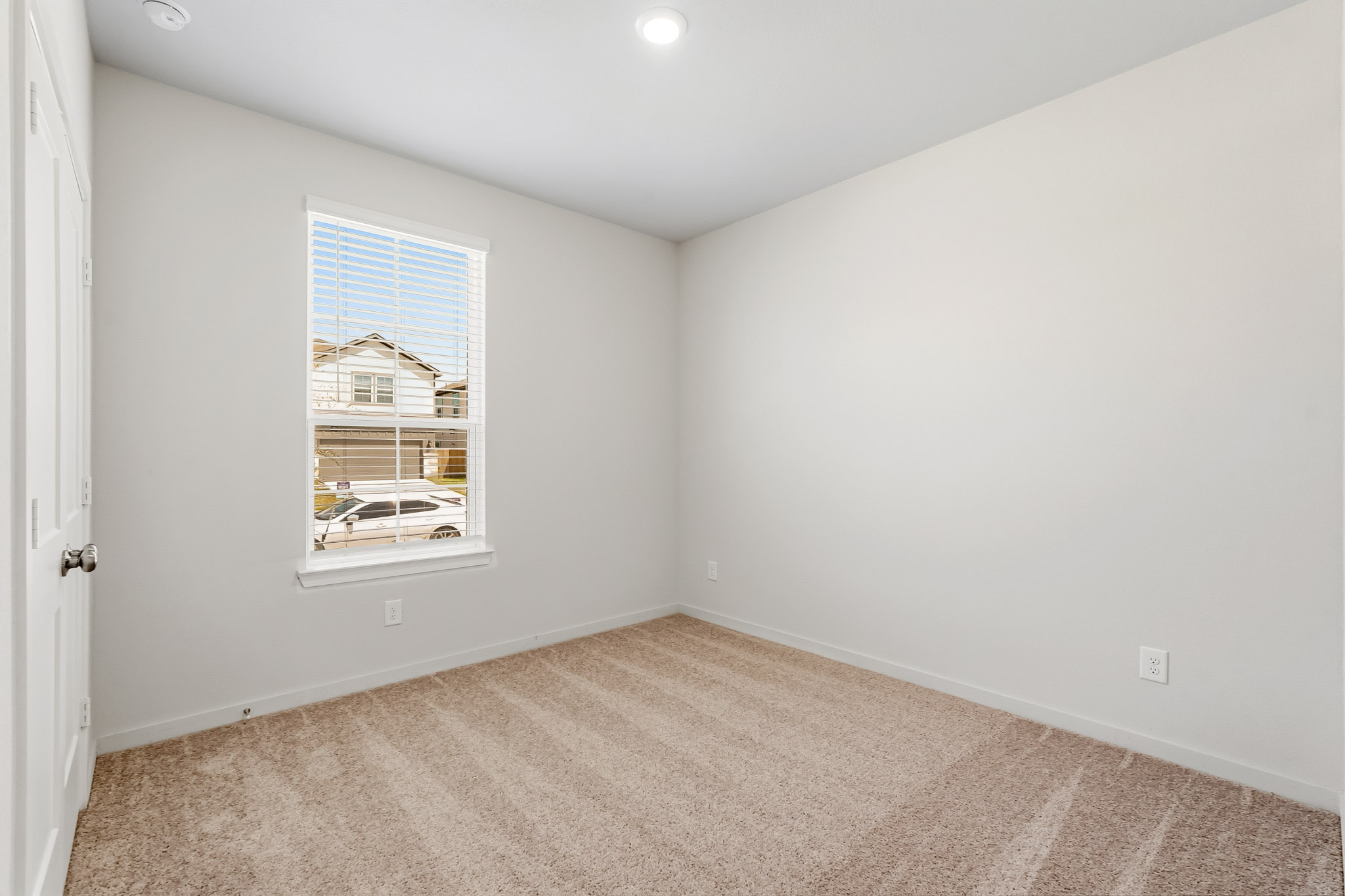 A room with a window and carpet.