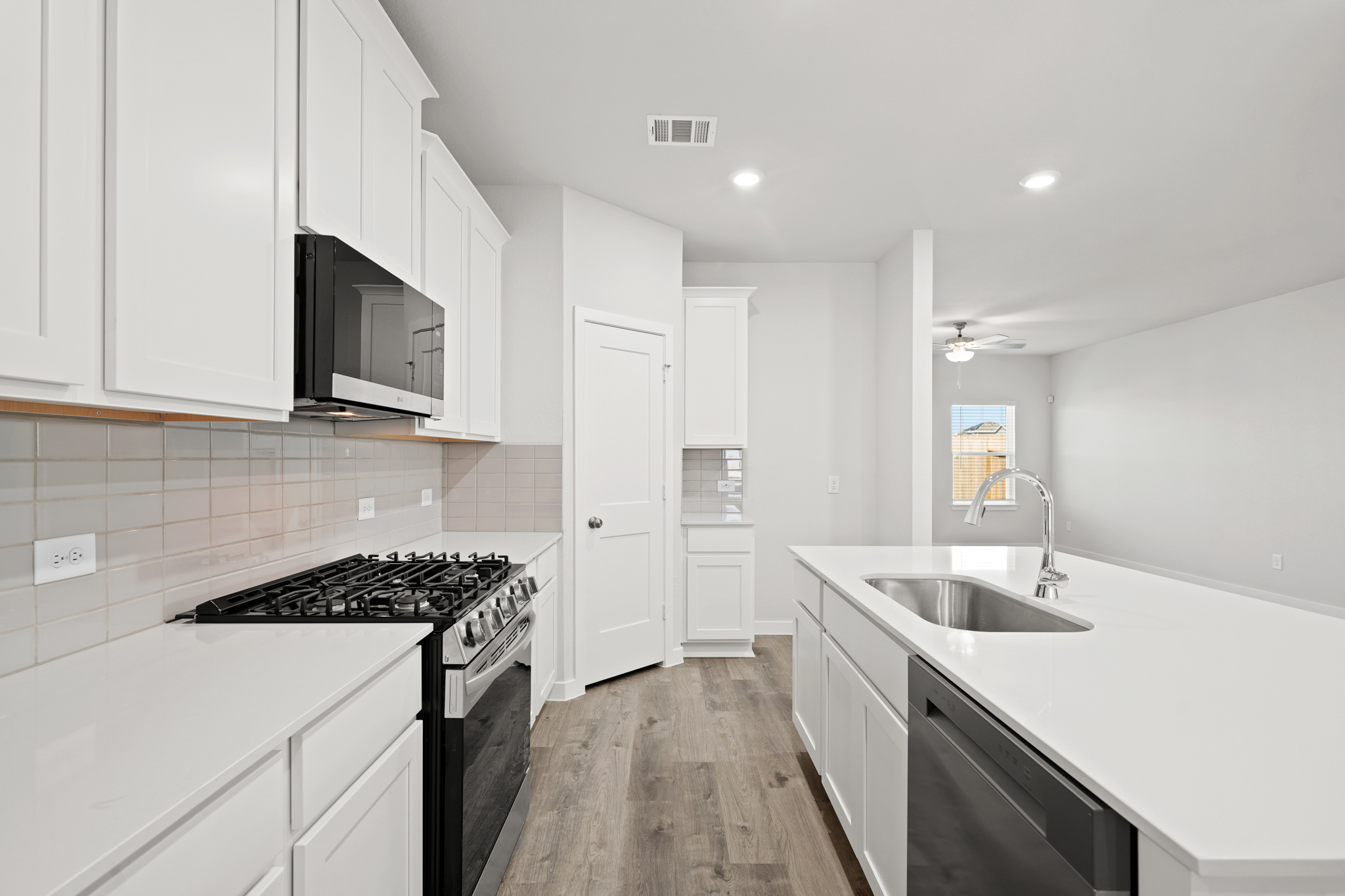 A kitchen with white cabinets.