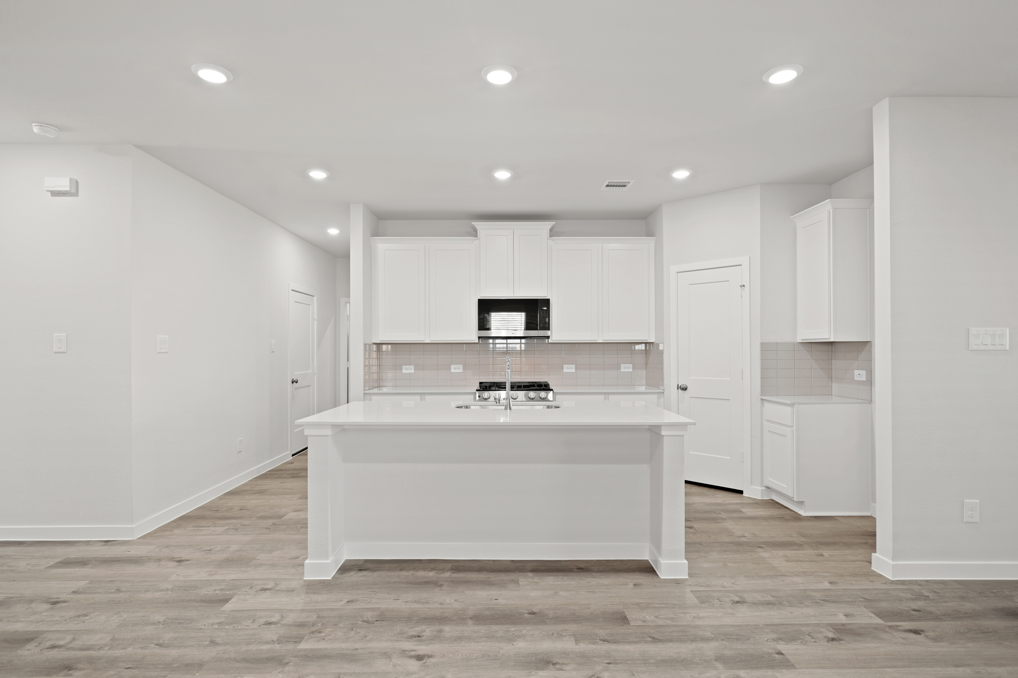 A large white kitchen with white cabinets.