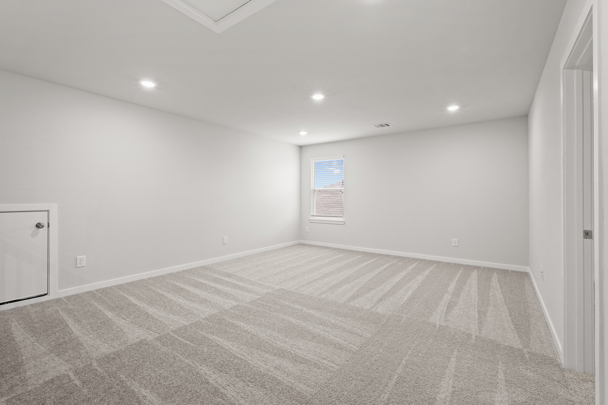 A room with a carpet and a door.