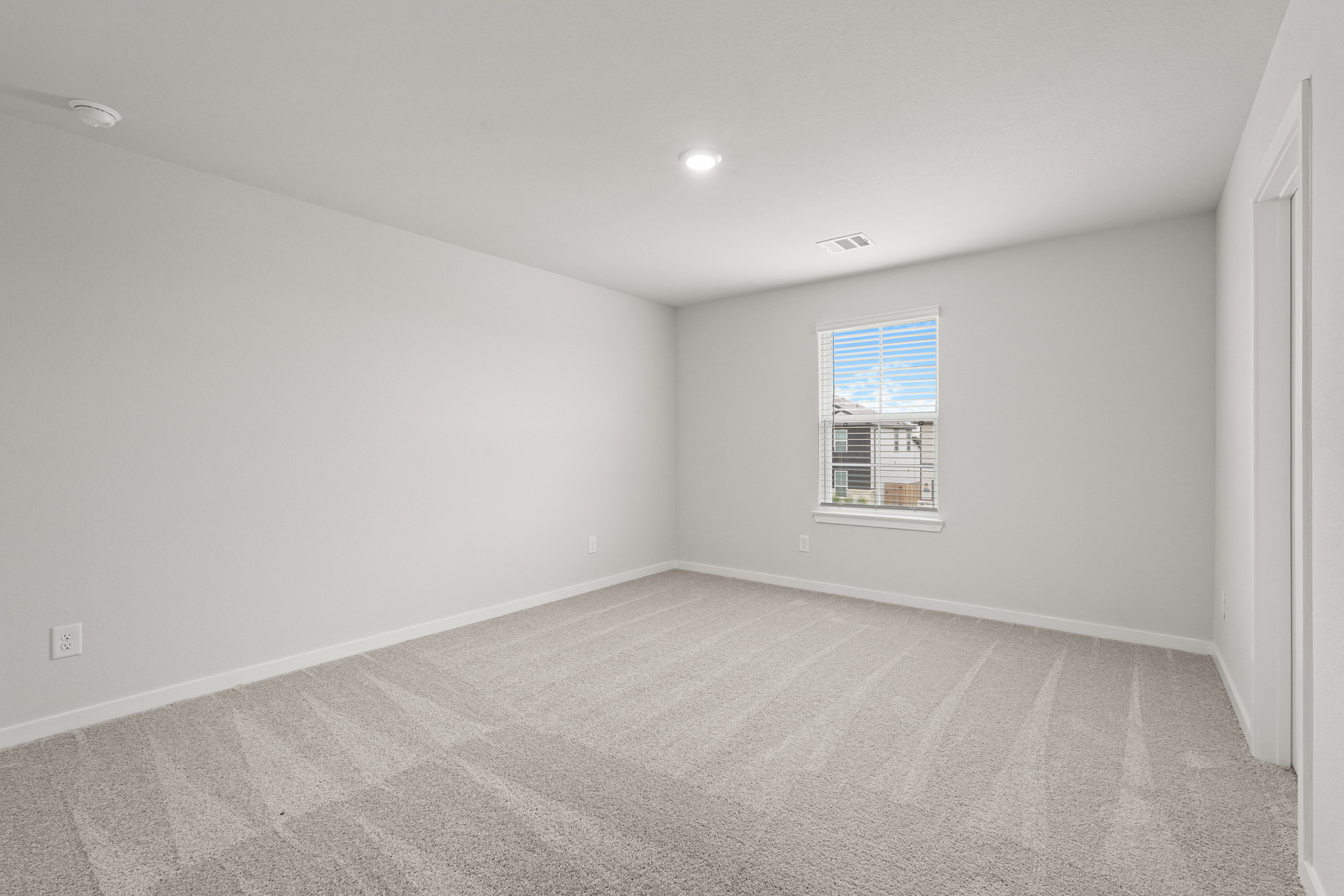 A room with a carpet and a window.