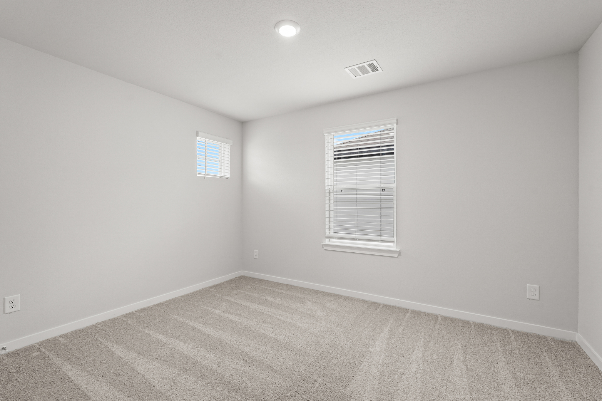 A room with a window and a carpet.