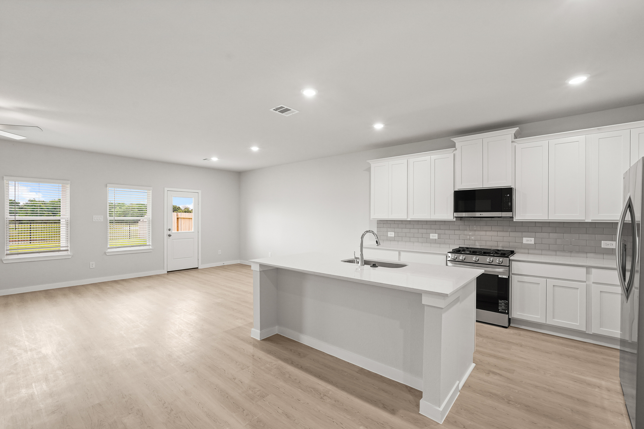 A kitchen with white cabinets.
