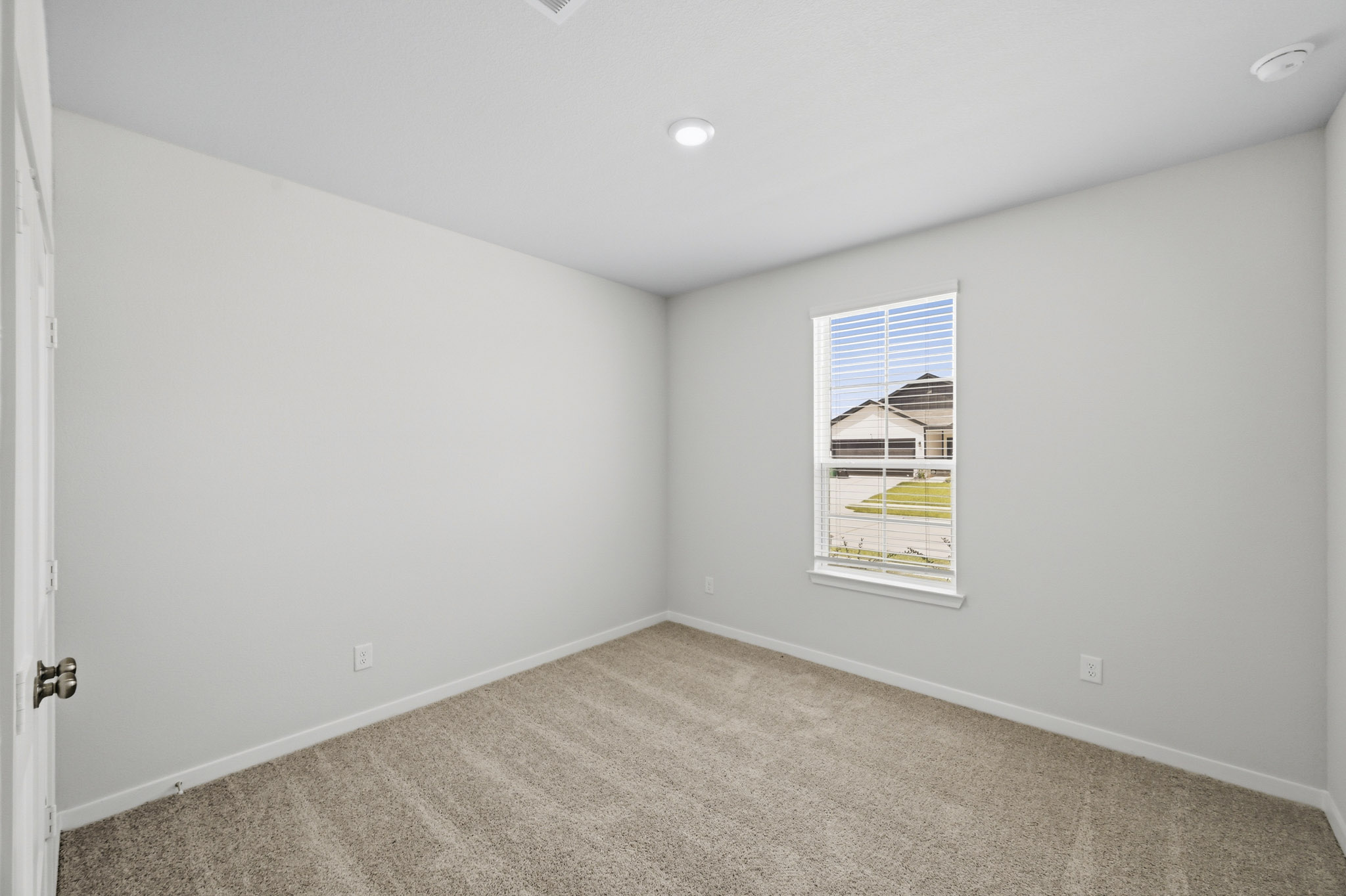 A room with a window and carpet.