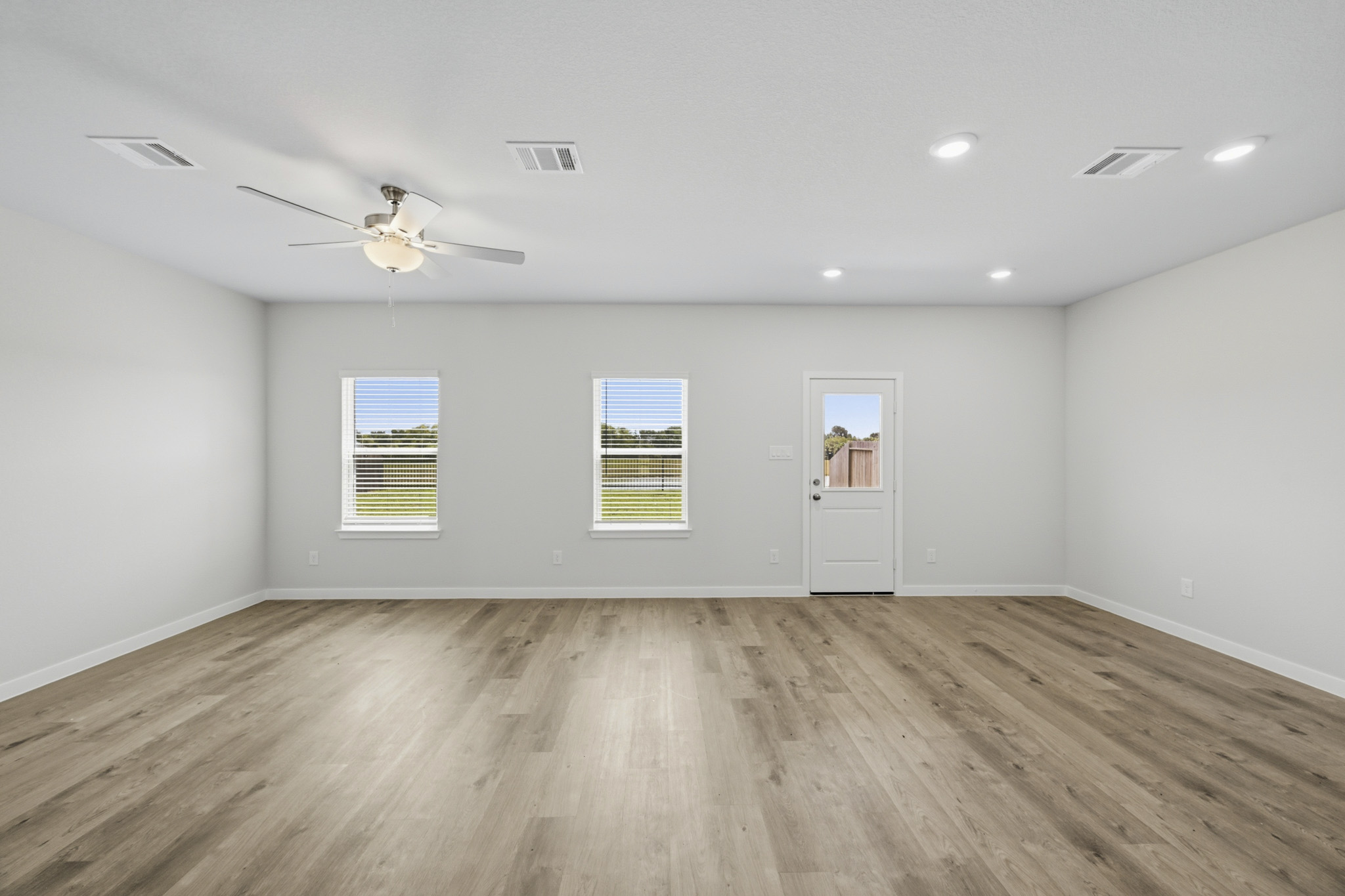 A room with a wood floor and a ceiling fan.