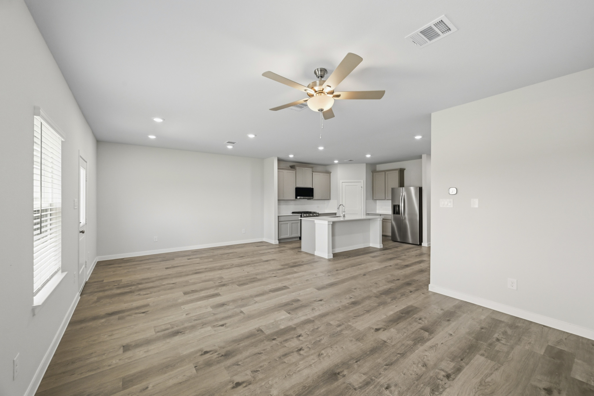 A large kitchen with a wood floor.