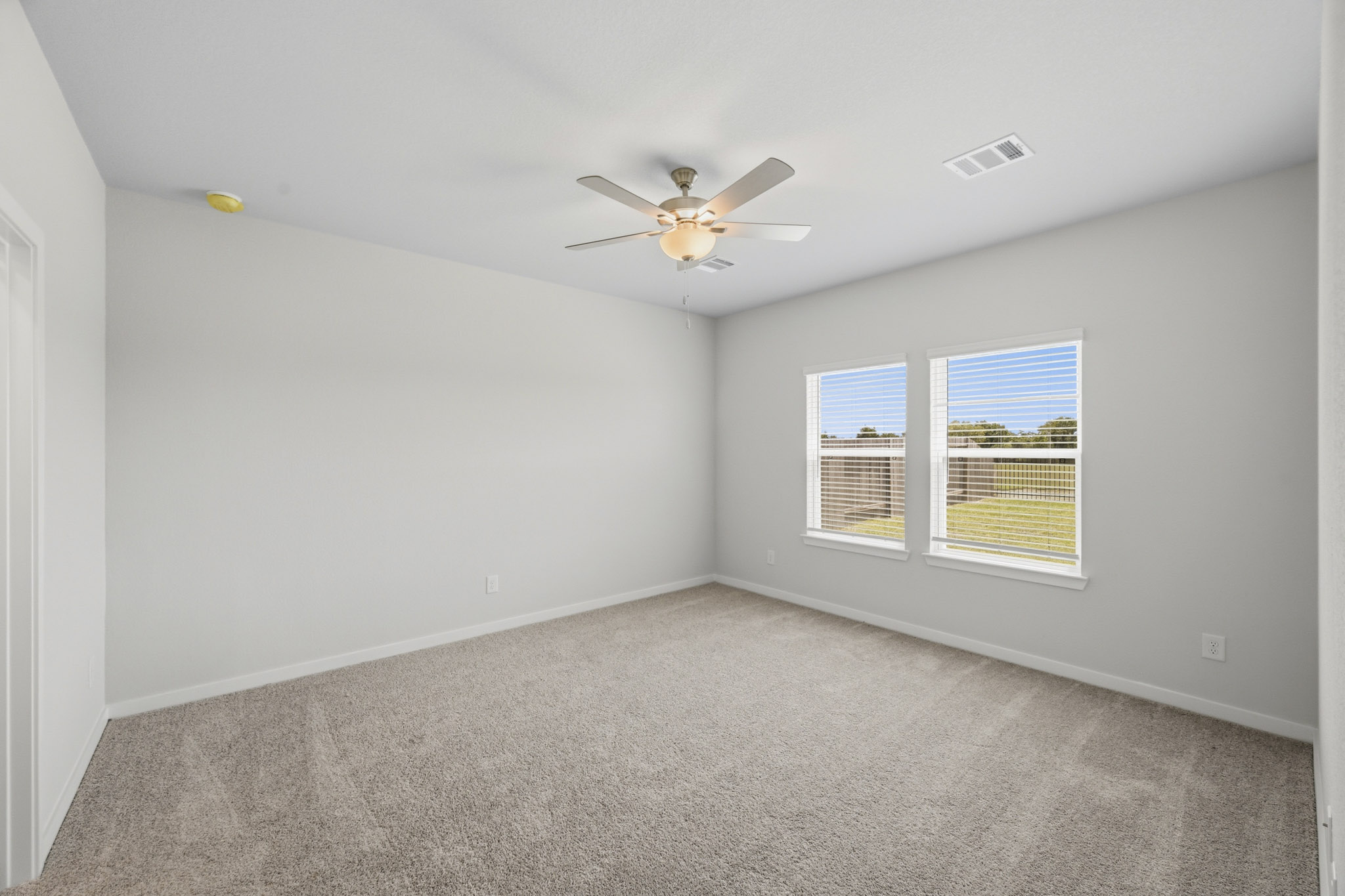 A room with a ceiling fan and a window.