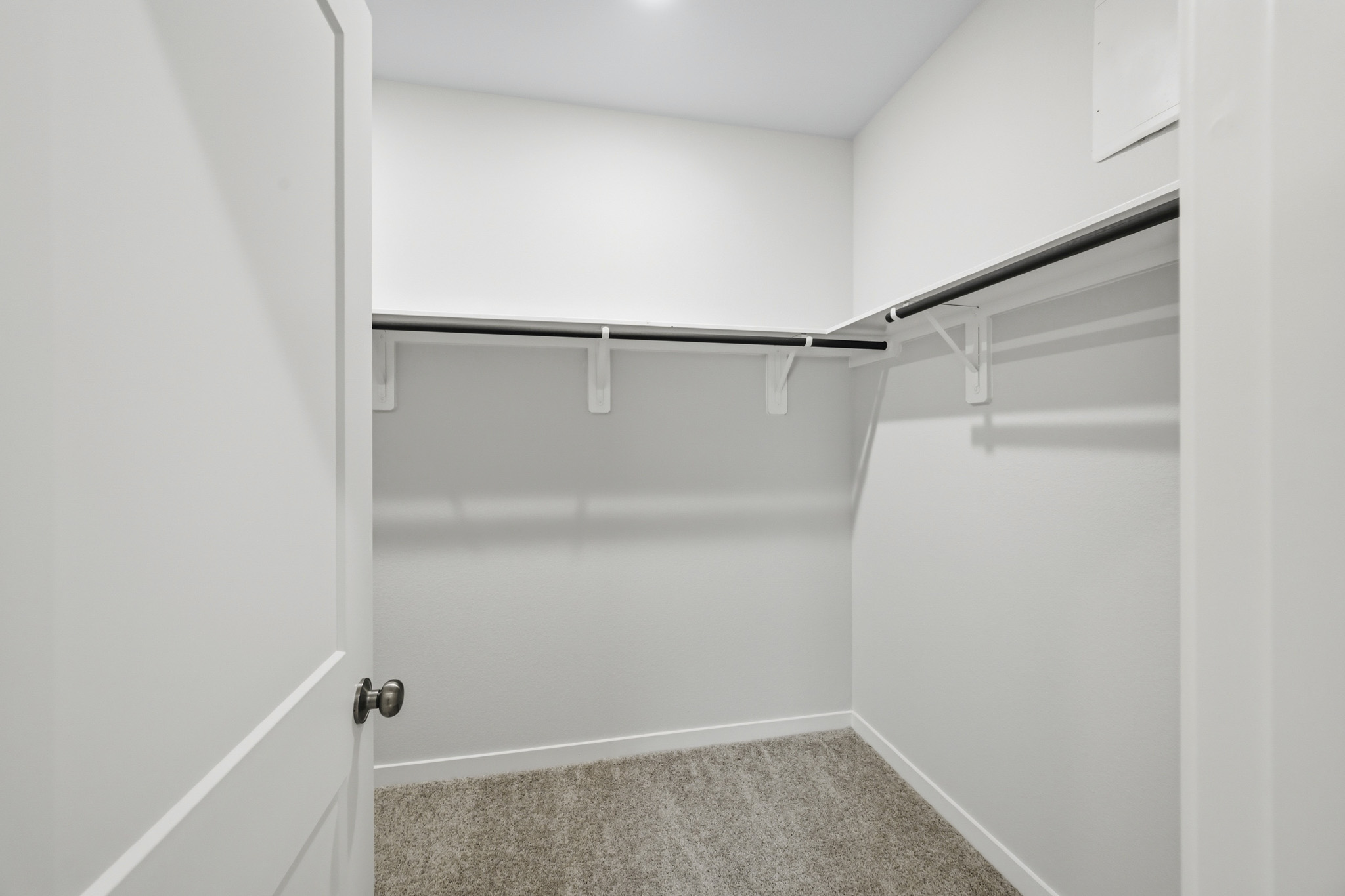 A white door with a metal bar.