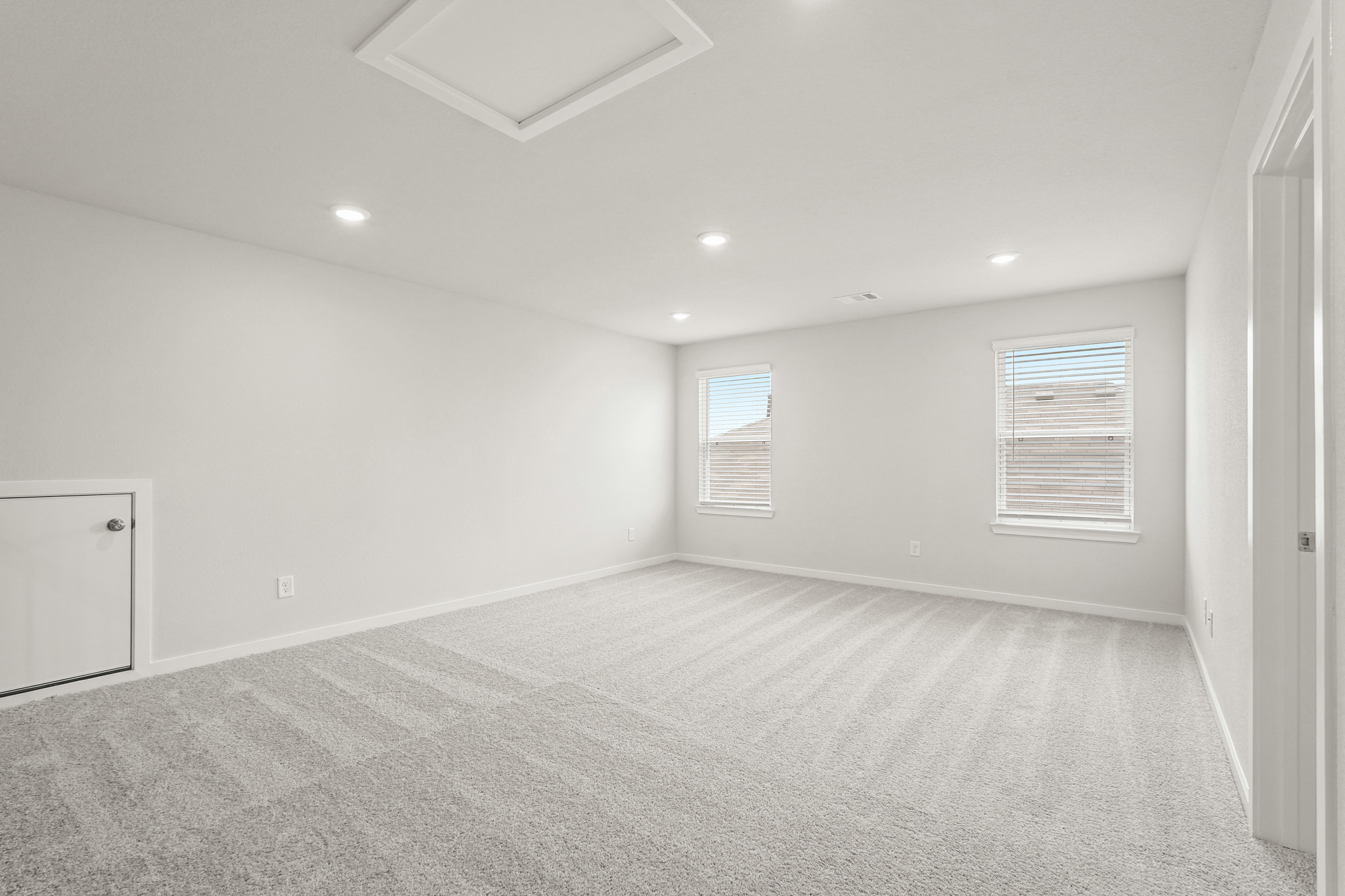 A room with a carpet and windows.