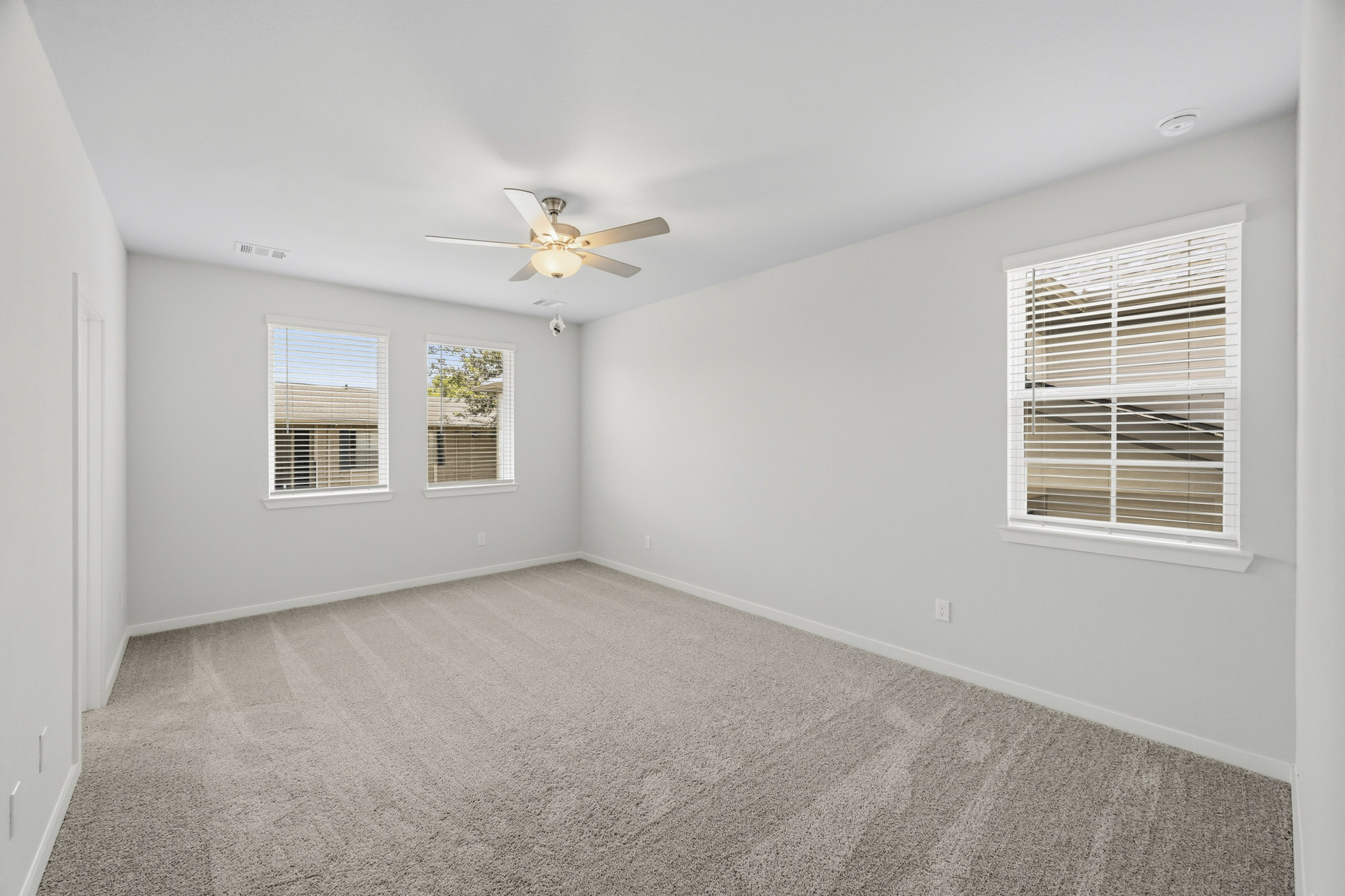 A room with a ceiling fan and a window.