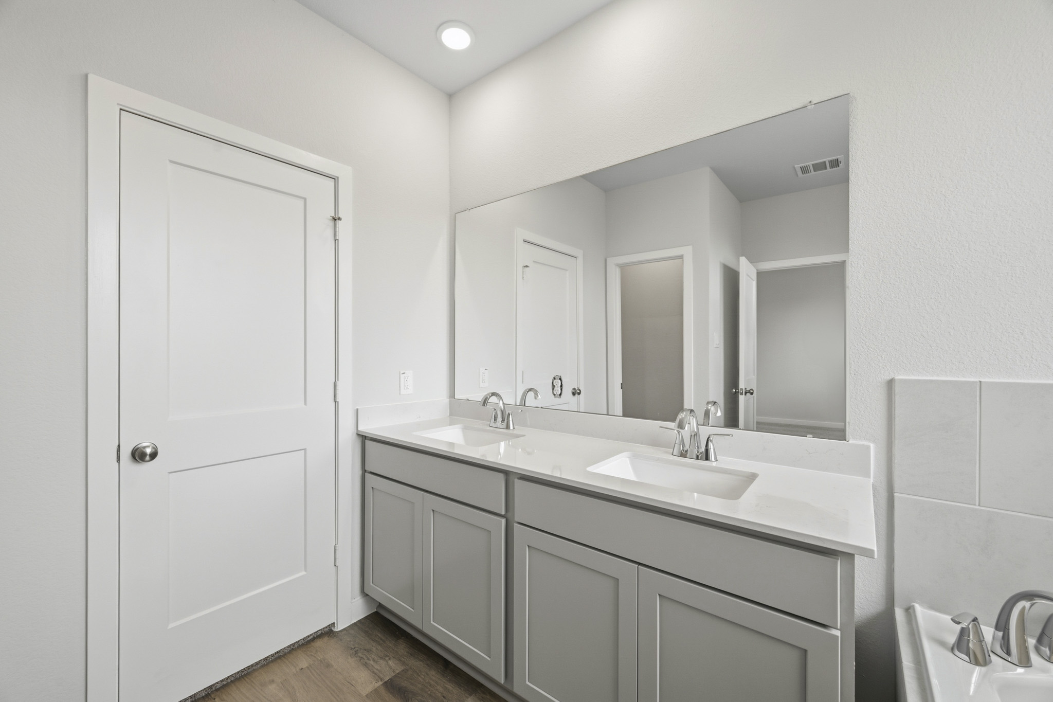 A bathroom with a large mirror.