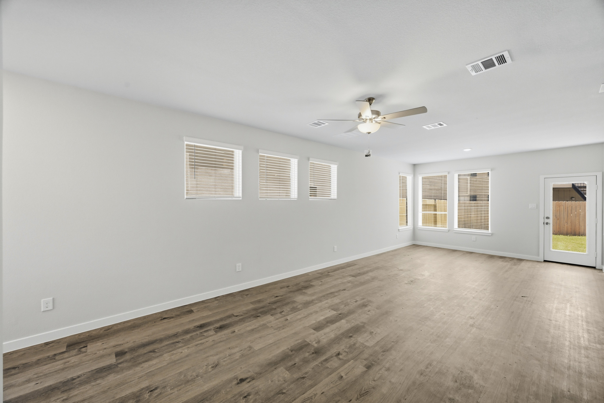 A room with a wood floor and a ceiling fan.