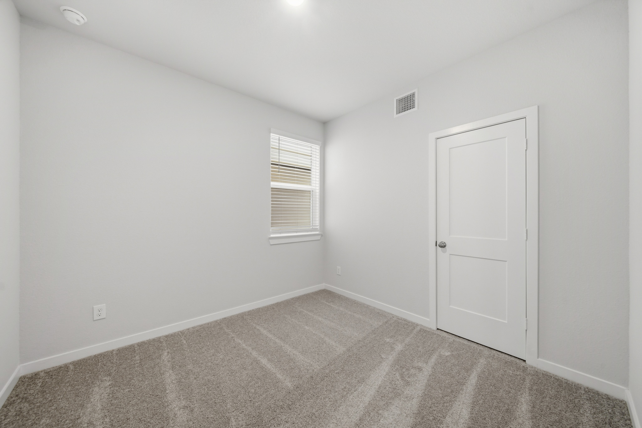 A room with a door and a rug.