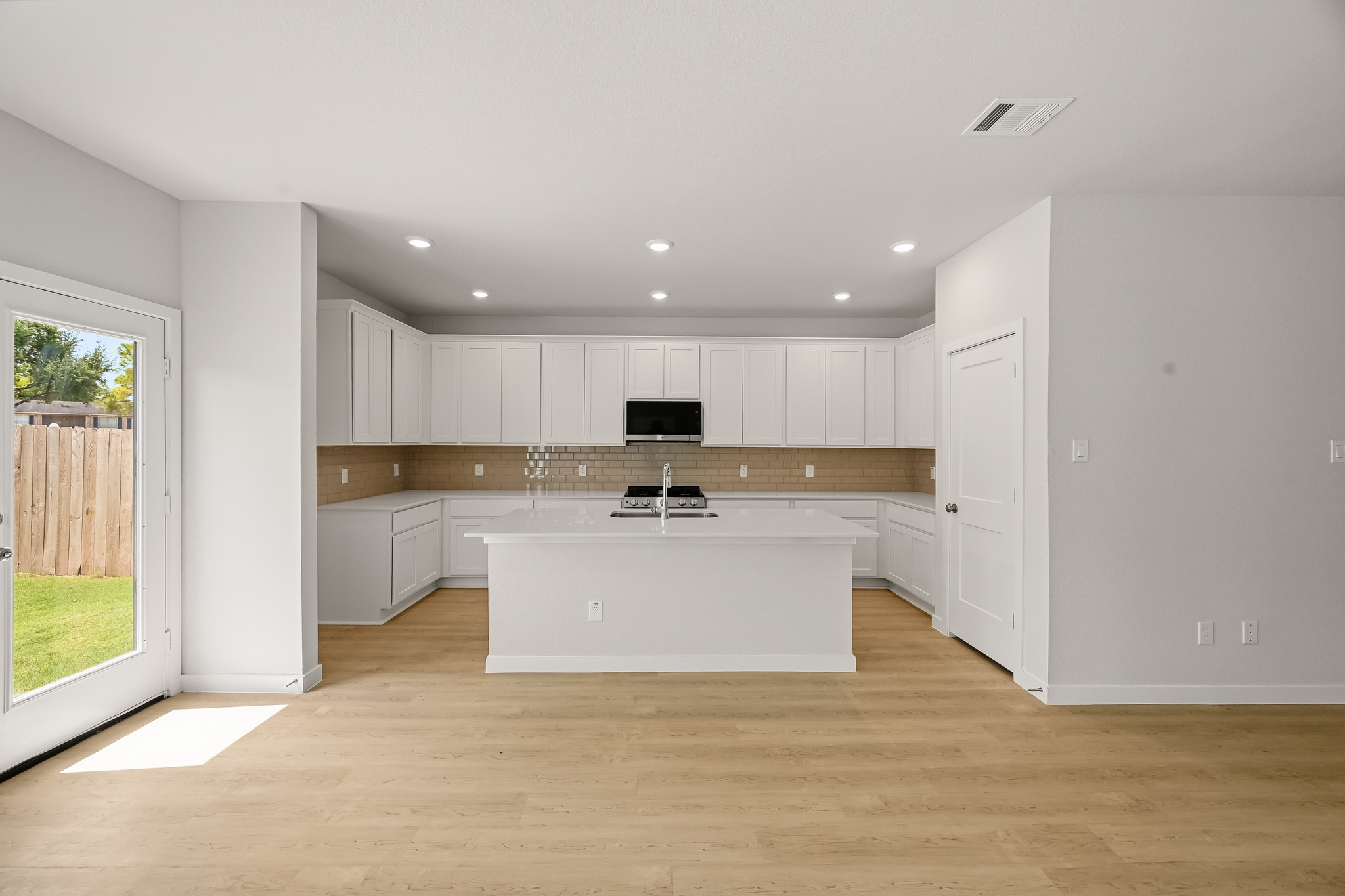 A kitchen with white cabinets.