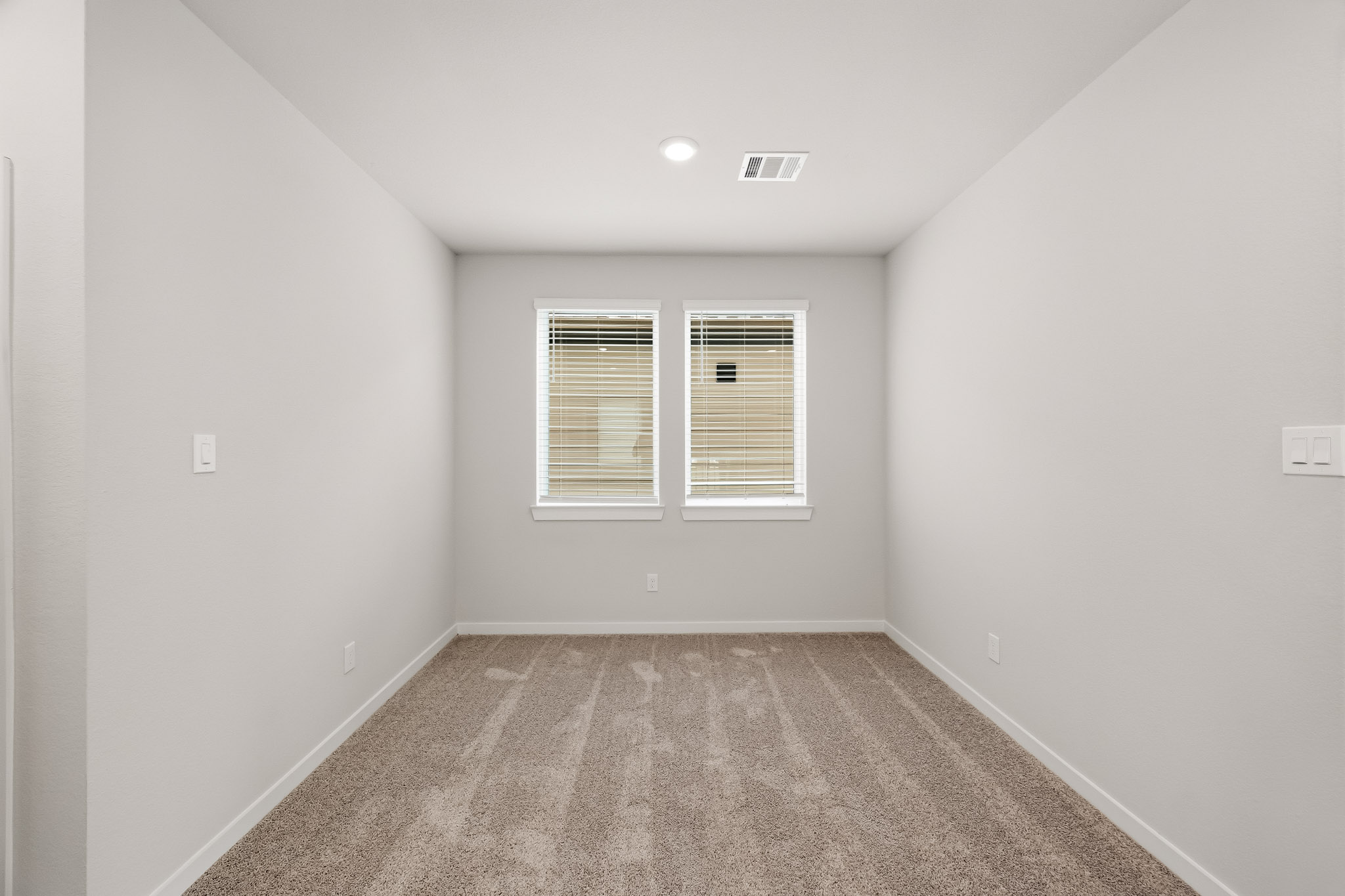A room with a carpet and a window.