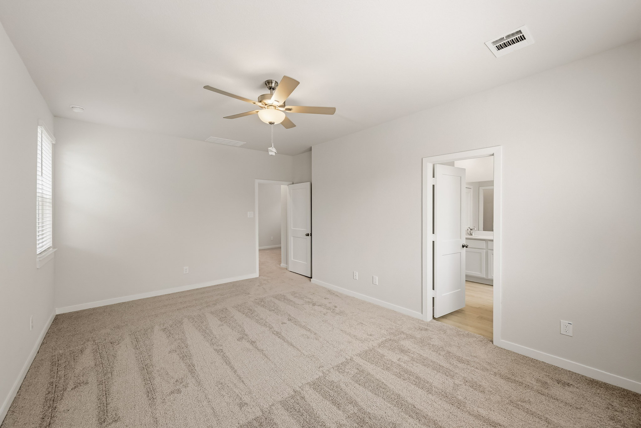 A room with a ceiling fan and a door.
