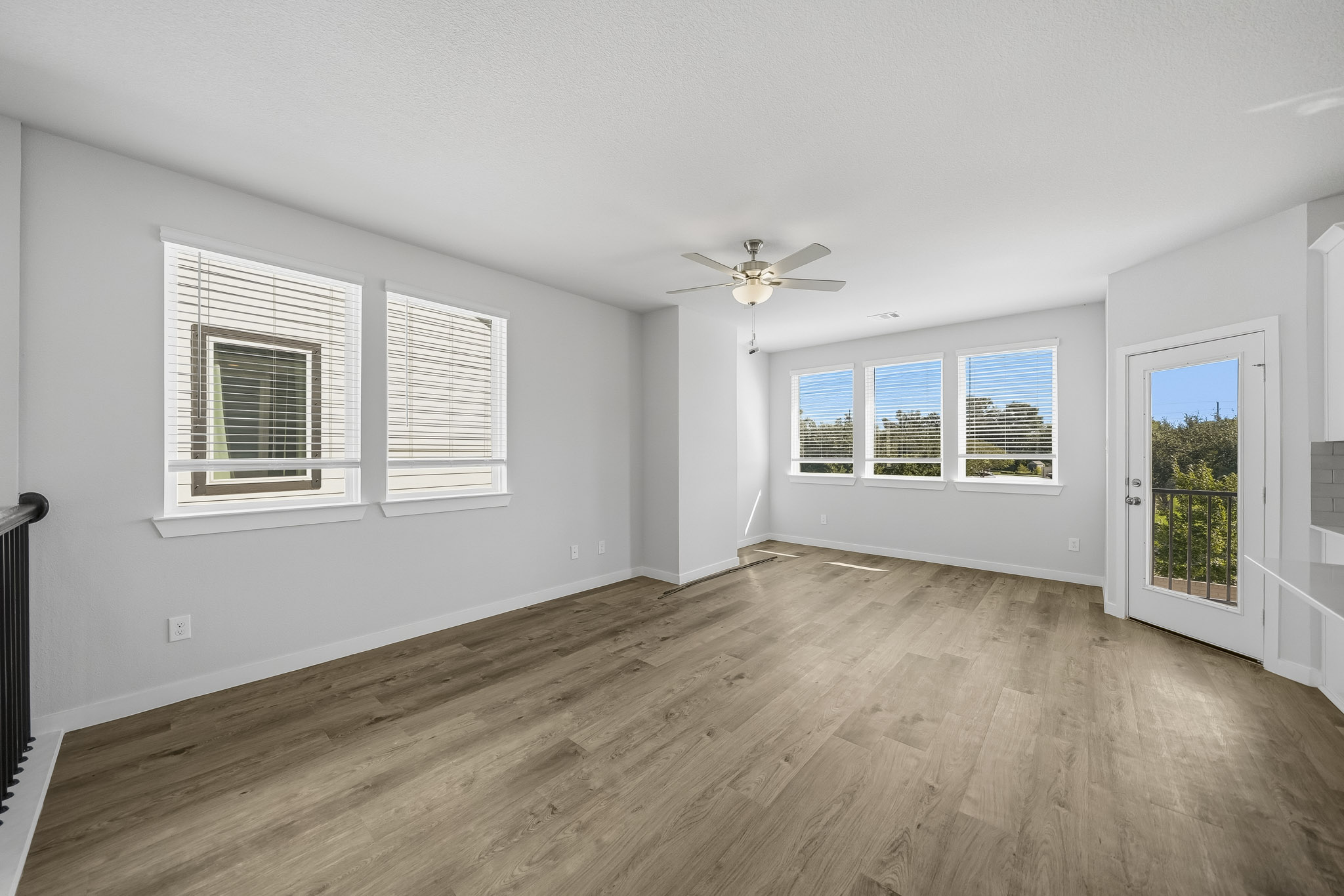 A room with a wood floor and a ceiling fan.
