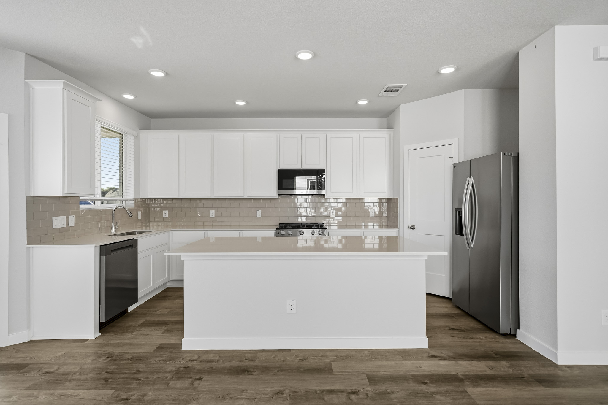 A kitchen with white cabinets.