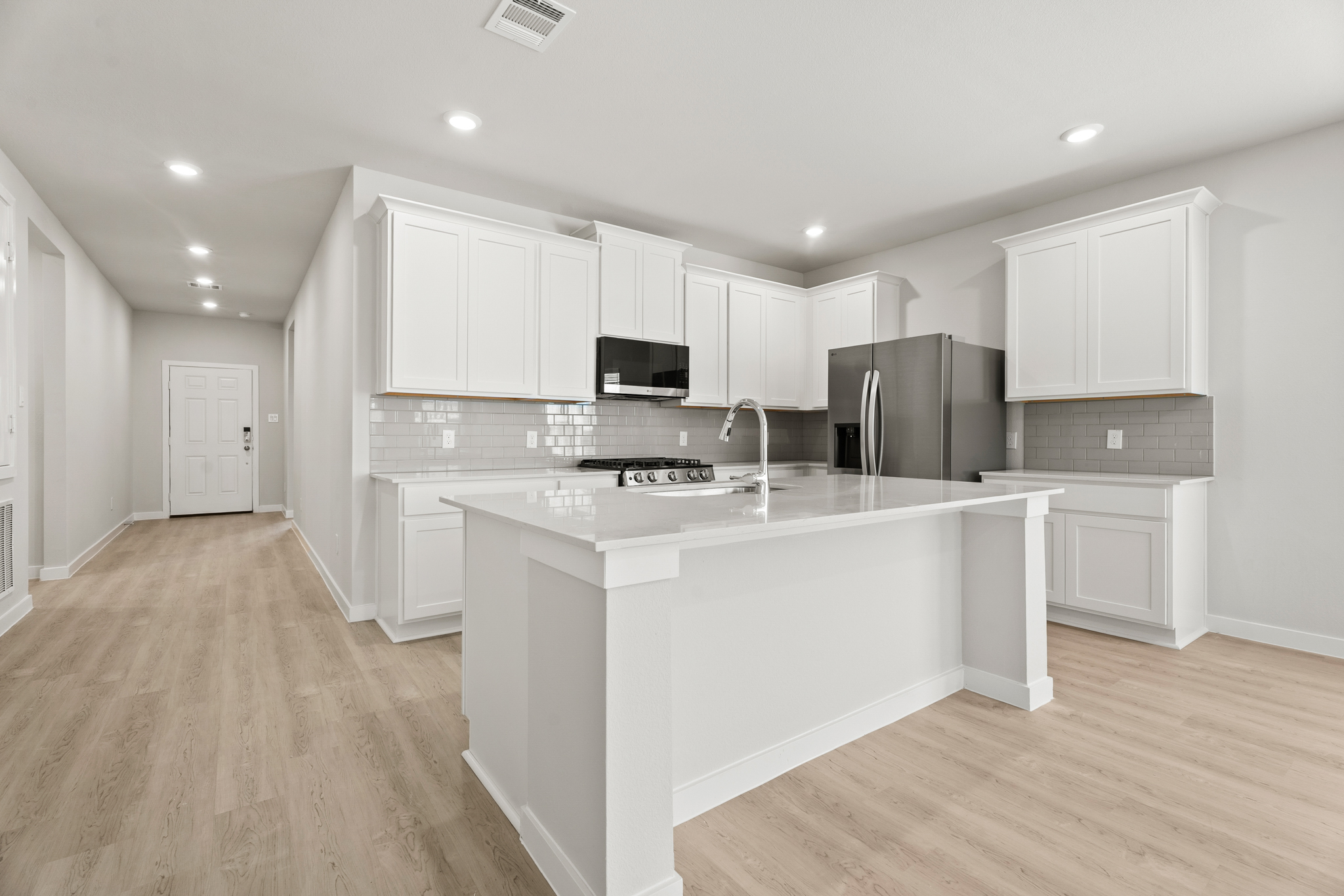 A kitchen with white cabinets.