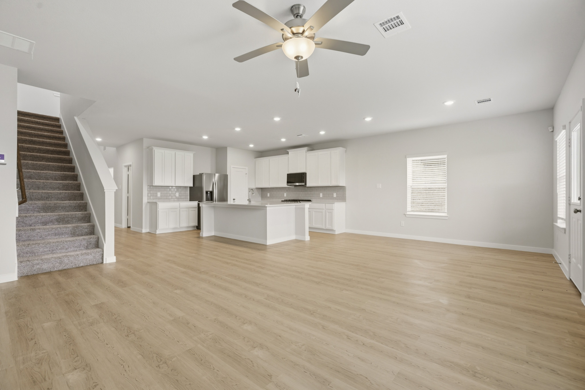 A large kitchen with a wood floor.
