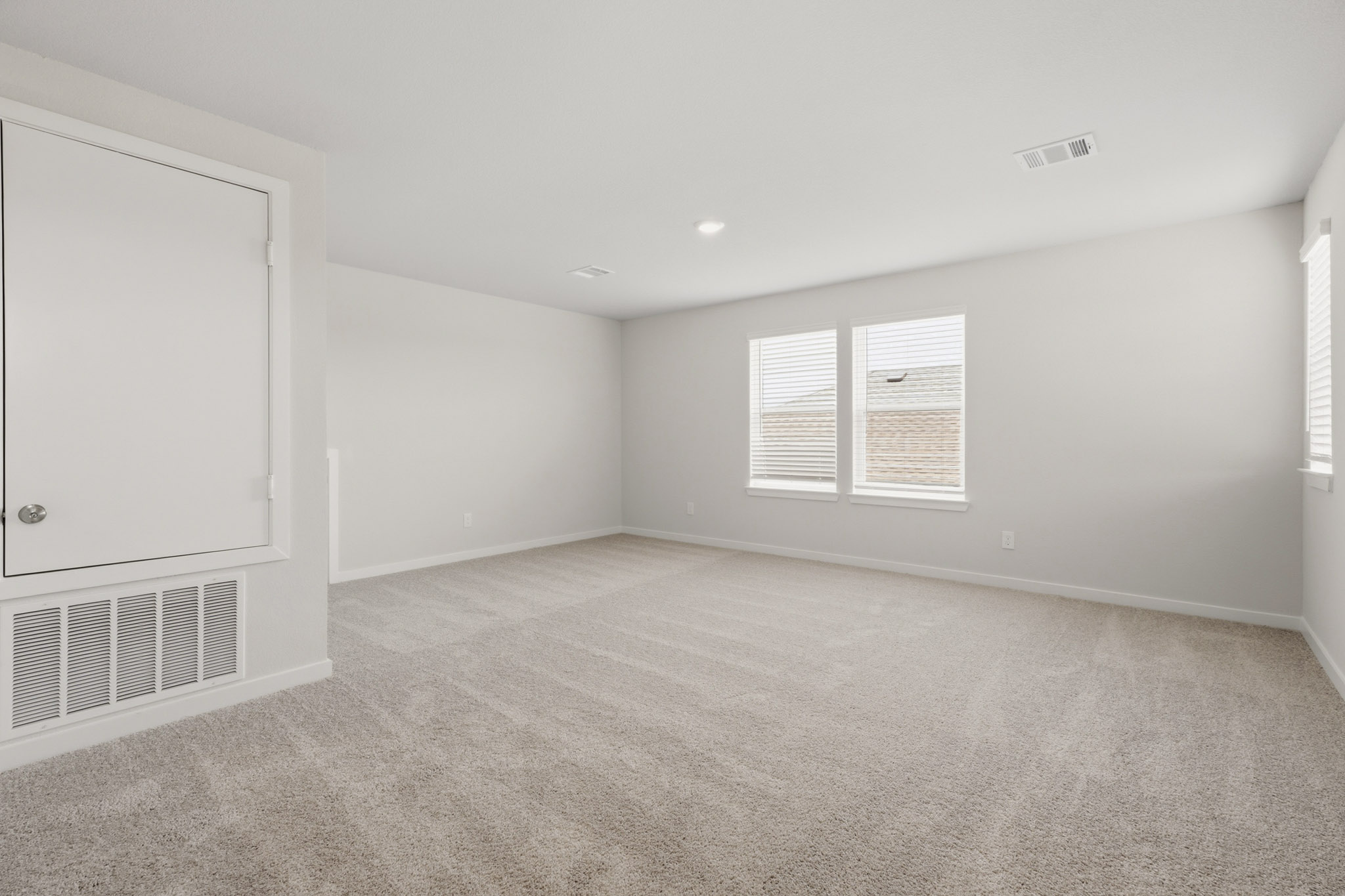 A room with a carpet and a vent.