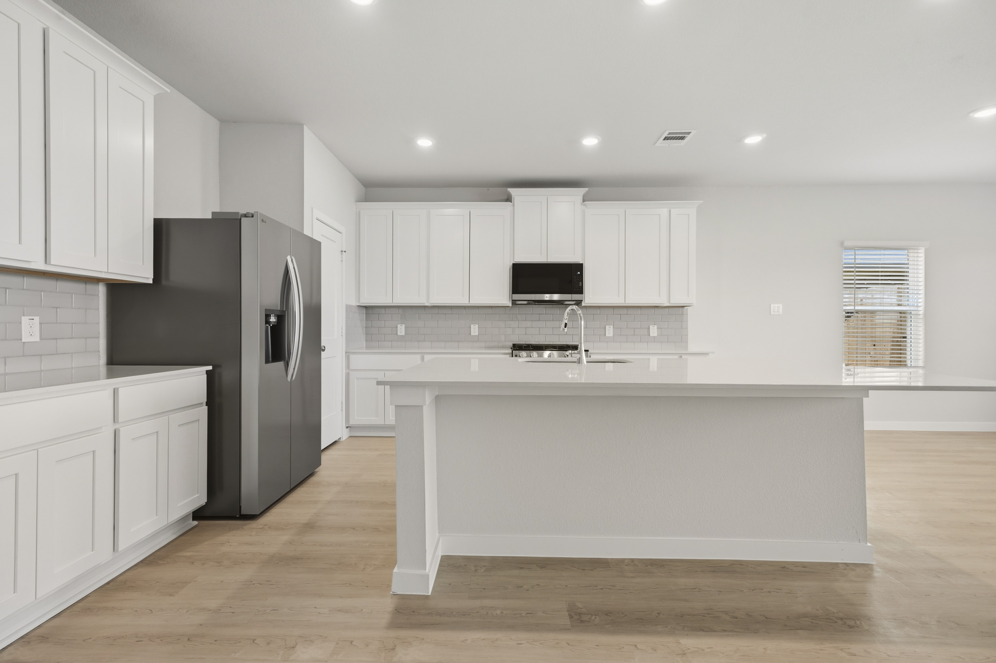 A kitchen with white cabinets.