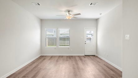 A room with a wood floor and a ceiling fan.