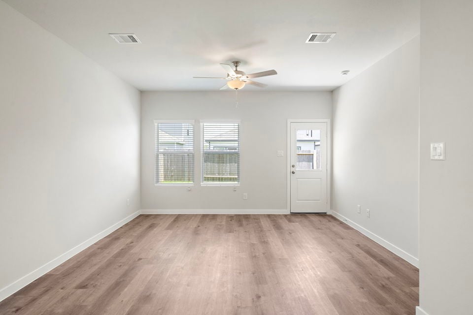 A room with a wood floor and a ceiling fan.