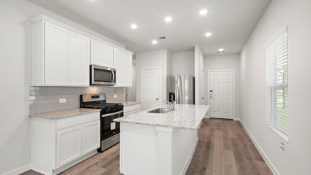 A kitchen with white cabinets.